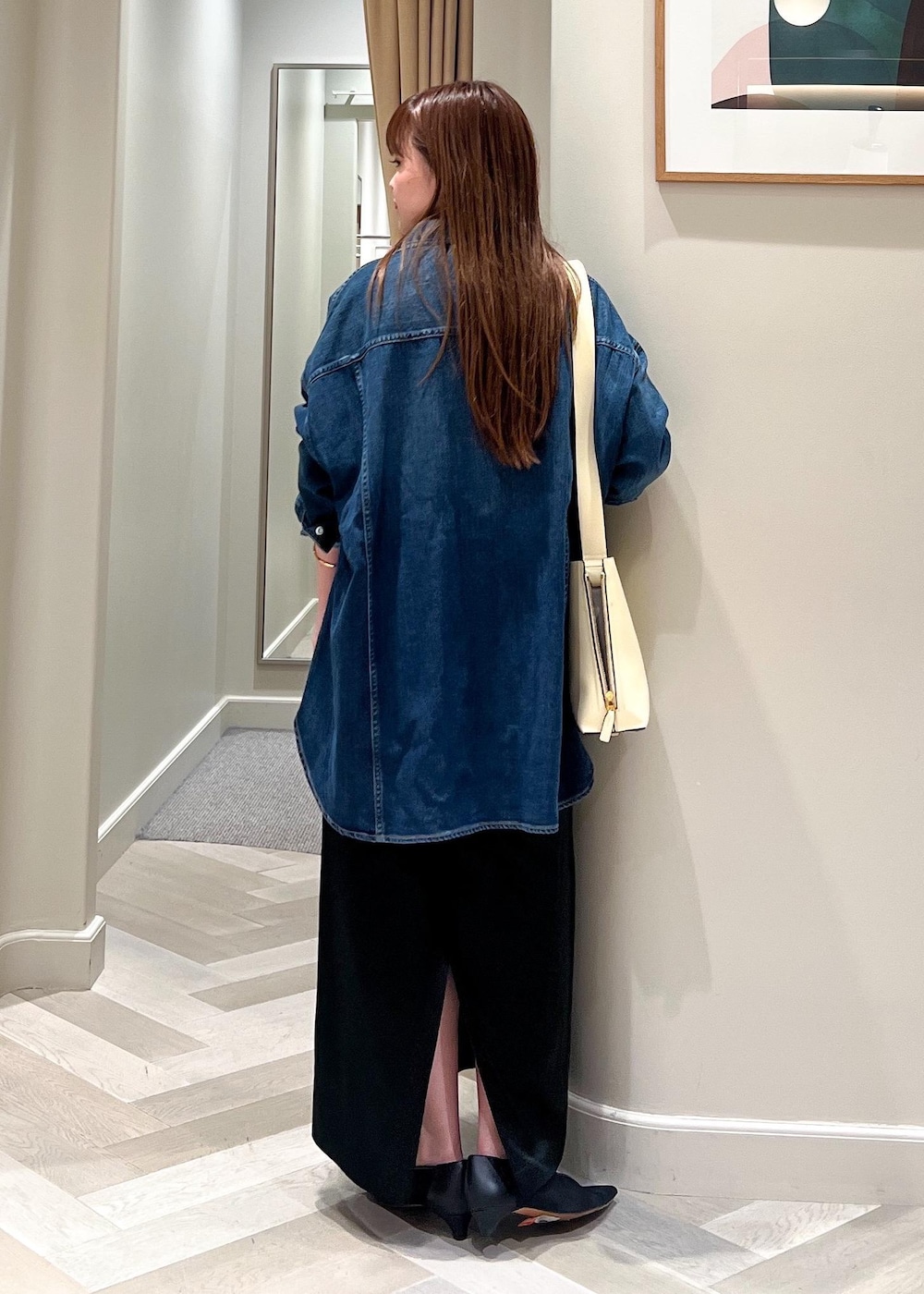 ホワイト系のショルダーバッグ、ブラック系のパンプス、ブラック系のスカートを着用したレディースの夏コーディネートの5枚目の写真