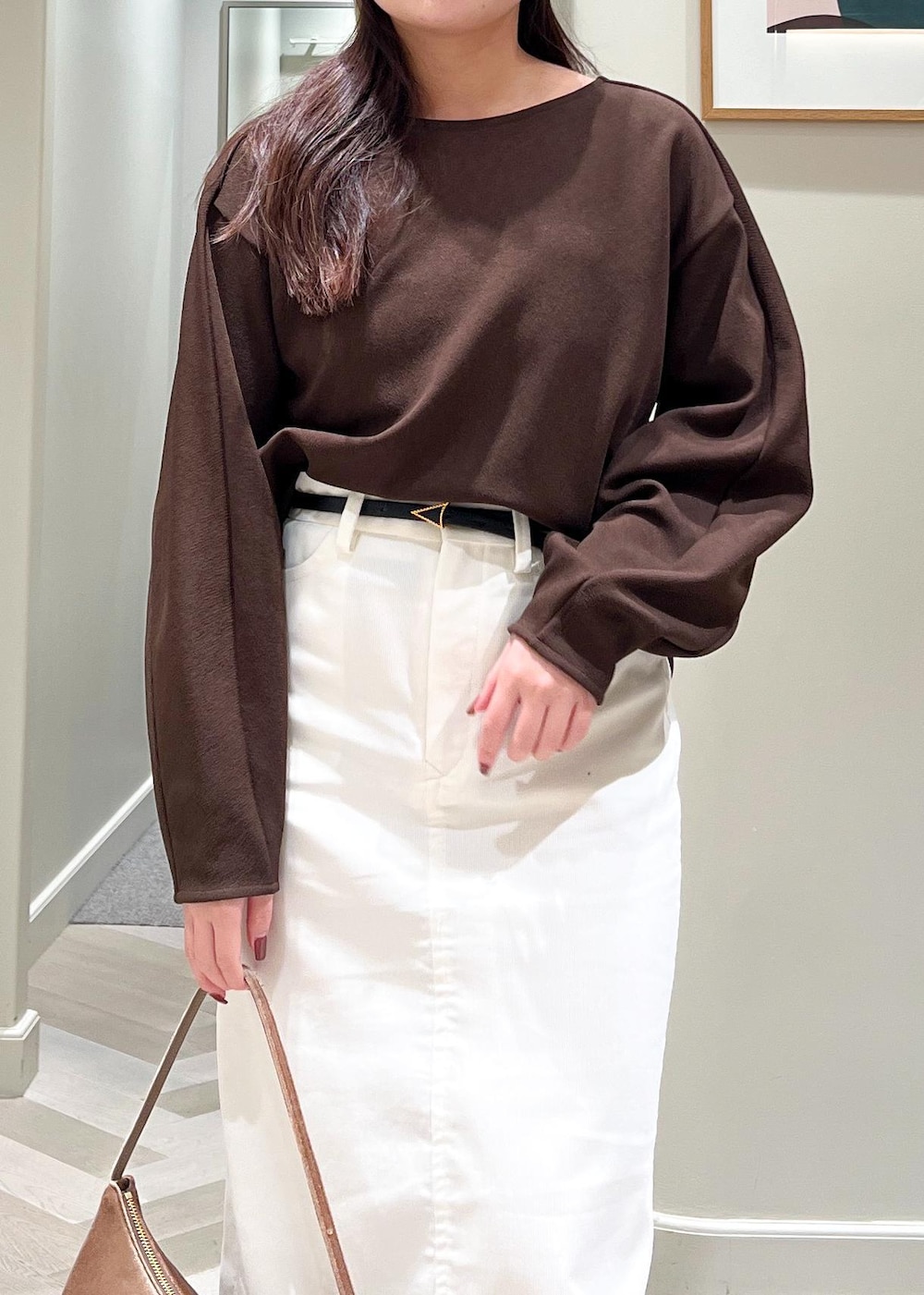 ブラック系のブーツ、ホワイト系のスカート、ブラウン系のTシャツ/カットソーを着用したレディースの秋コーディネートの6枚目の写真