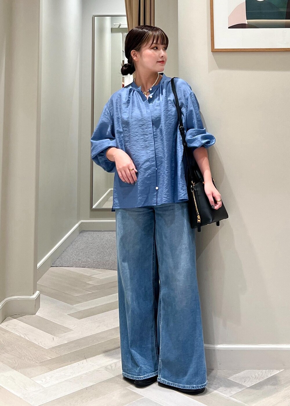 ブラック系のハンドバッグ、ブルー系のデニムパンツ、ブルー系のシャツ/ブラウスを着用したレディースの夏コーディネートの6枚目の写真