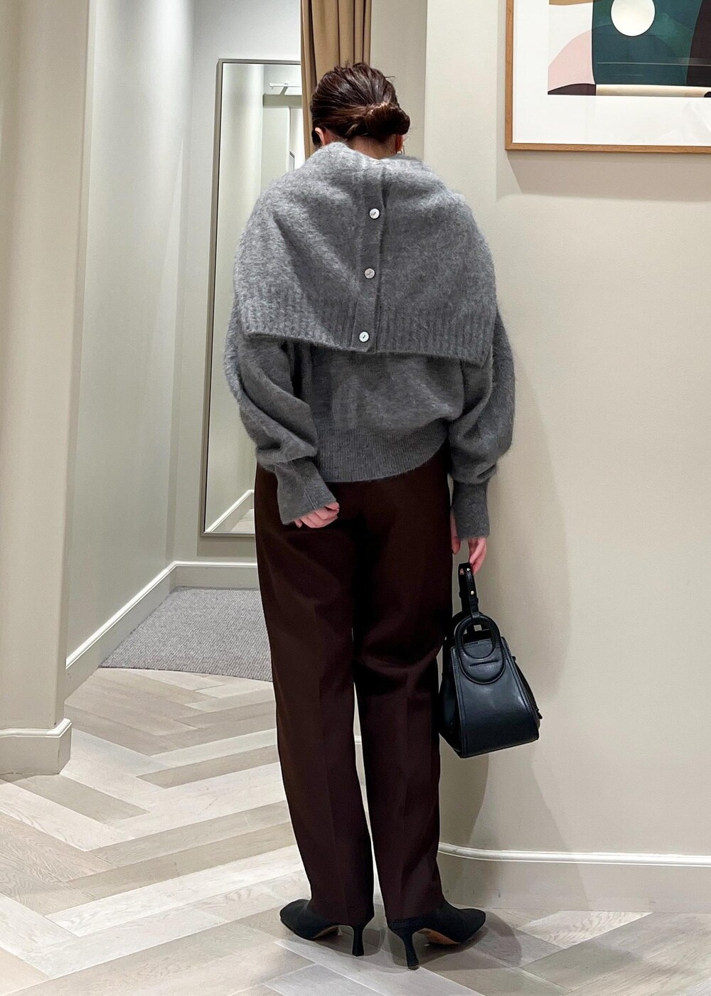ブラック系のハンドバッグ、ブラック系のブーツ、グレー系のカーディガン/ボレロを着用したレディースの秋コーディネートの4枚目の写真