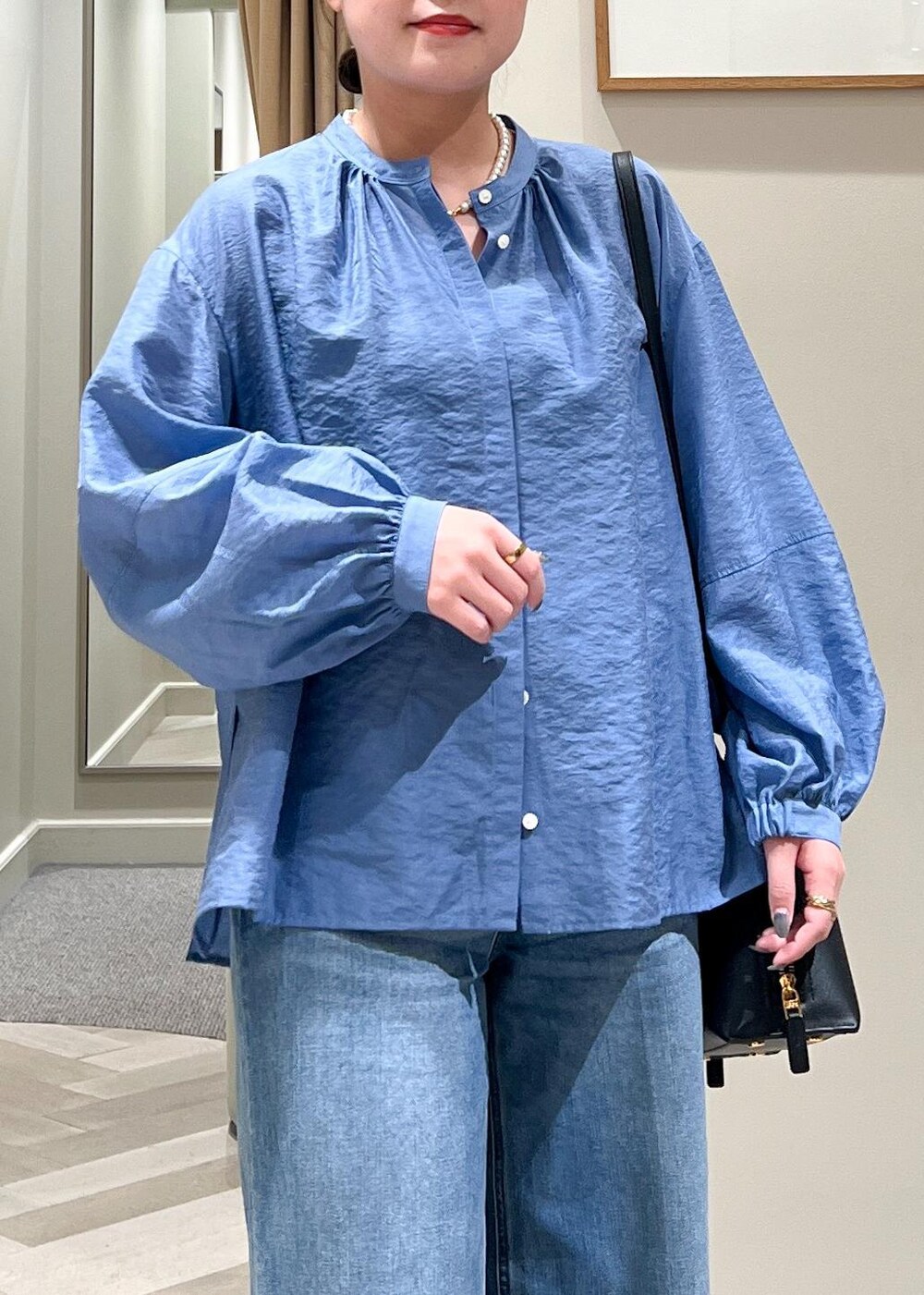 ブラック系のハンドバッグ、ブルー系のデニムパンツ、ブルー系のシャツ/ブラウスを着用したレディースの夏コーディネートの7枚目の写真