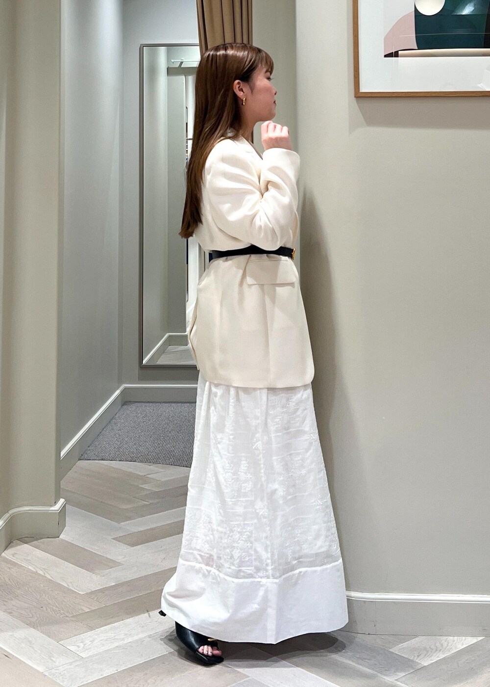 ホワイト系のテーラードジャケット、ブラック系のサンダル、ホワイト系のワンピースを着用したレディースの春コーディネートの3枚目の写真