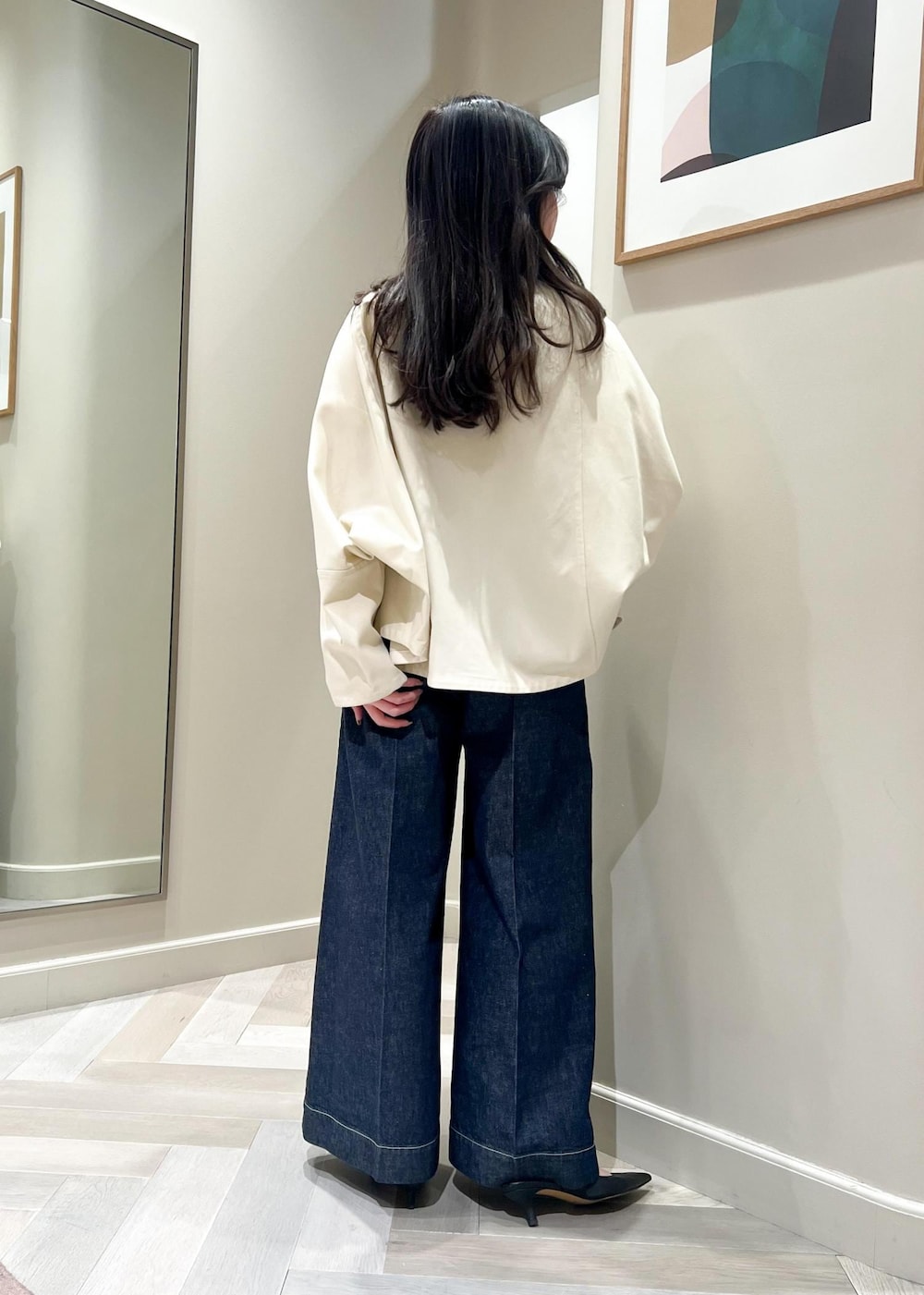 ブラック系のパンプス、ホワイト系のニット/セーター、ブルー系のデニムパンツを着用したレディースの春コーディネートの4枚目の写真