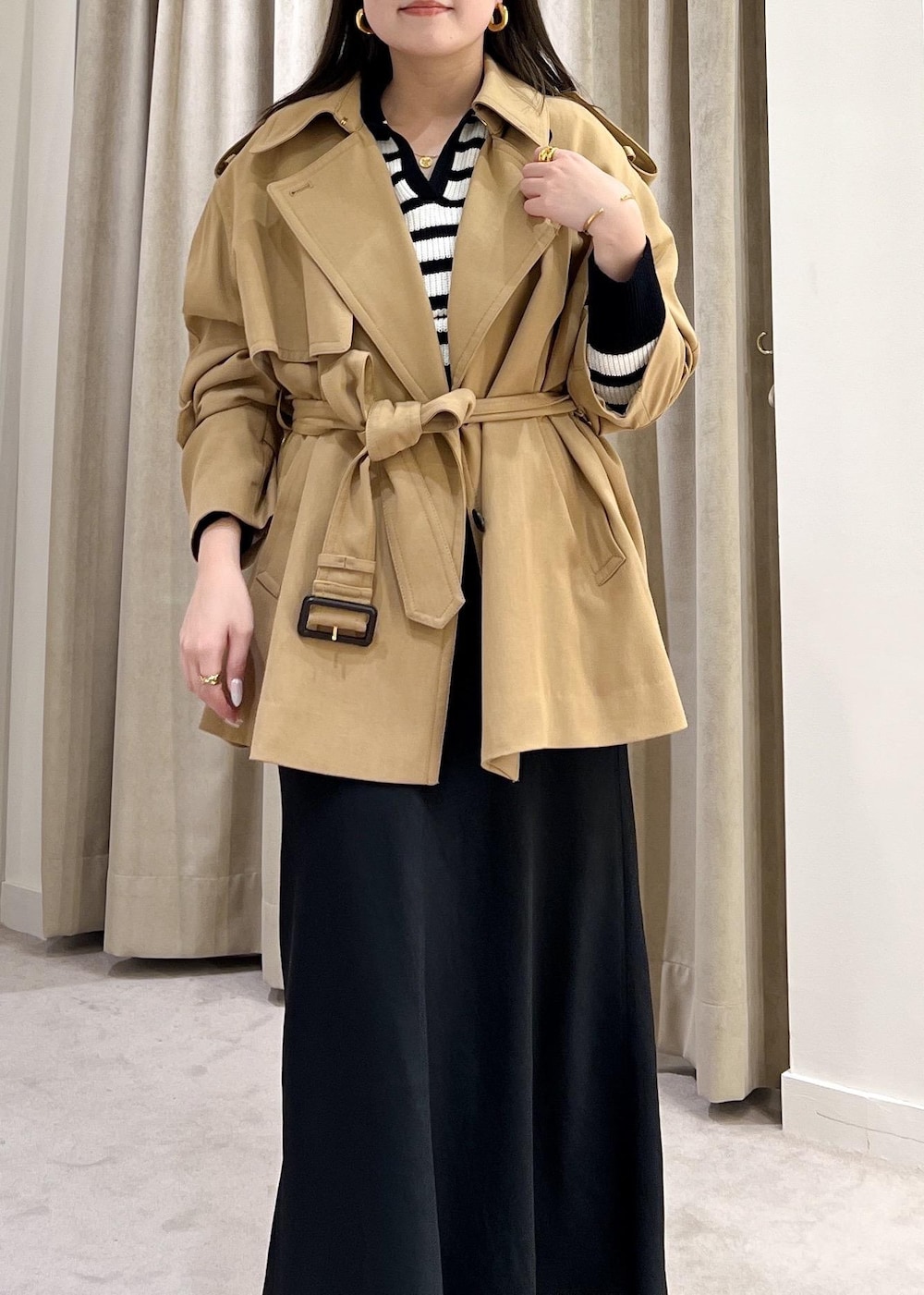 ブラック系のスカート、ベージュ系のトレンチコート、ホワイト系のニット/セーターを着用したレディースの冬コーディネートの8枚目の写真