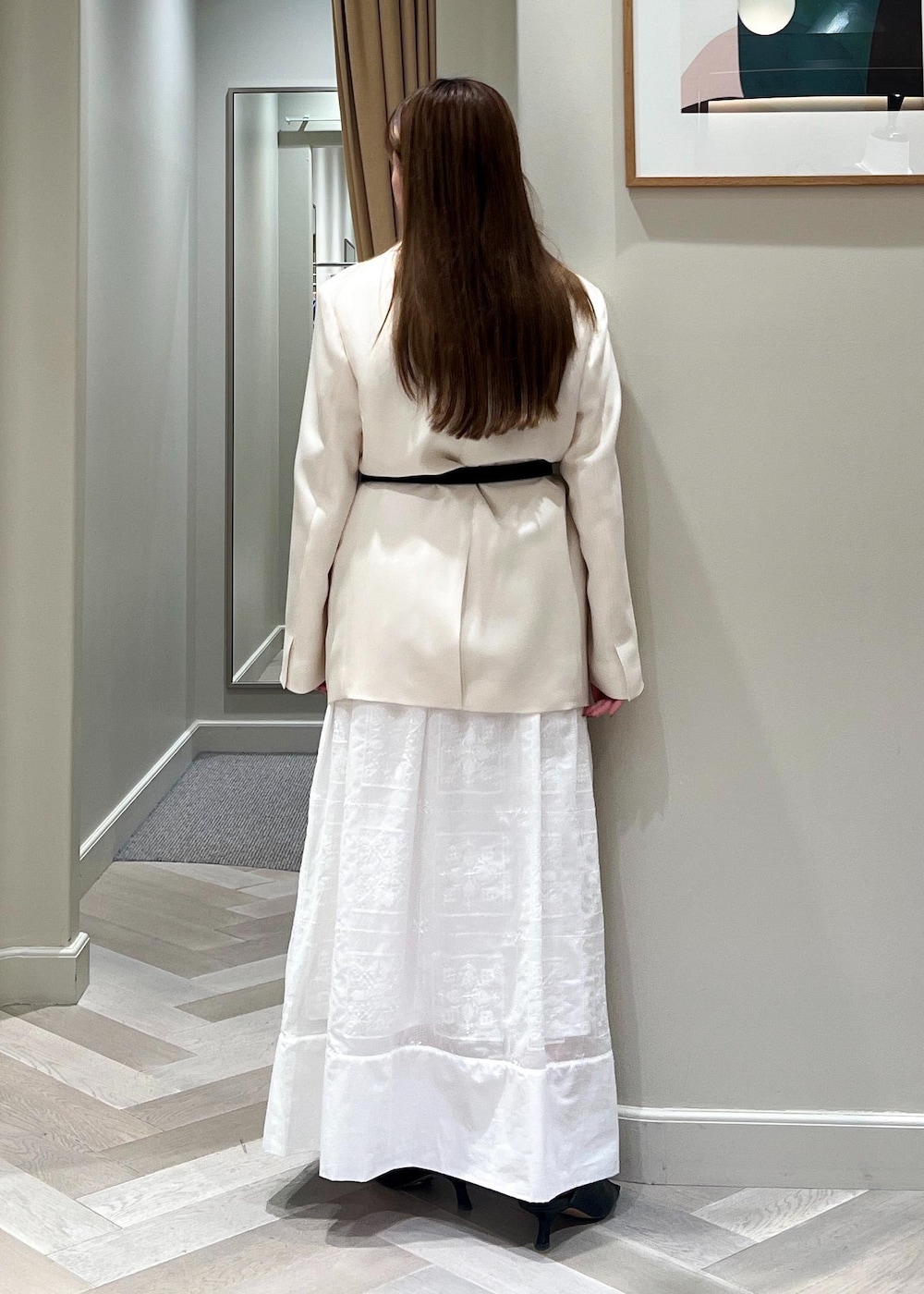 ホワイト系のテーラードジャケット、ブラック系のサンダル、ホワイト系のワンピースを着用したレディースの春コーディネートの4枚目の写真