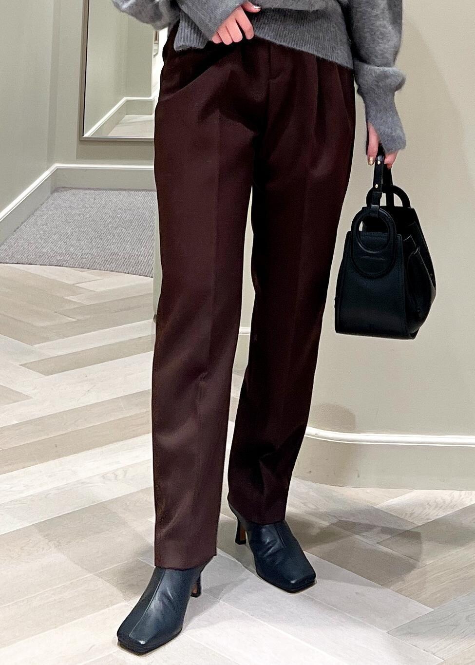 ブラック系のハンドバッグ、ブラック系のブーツ、グレー系のカーディガン/ボレロを着用したレディースの秋コーディネートの7枚目の写真