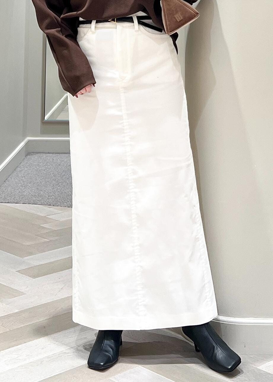 ブラック系のブーツ、ホワイト系のスカート、ブラウン系のTシャツ/カットソーを着用したレディースの秋コーディネートの7枚目の写真