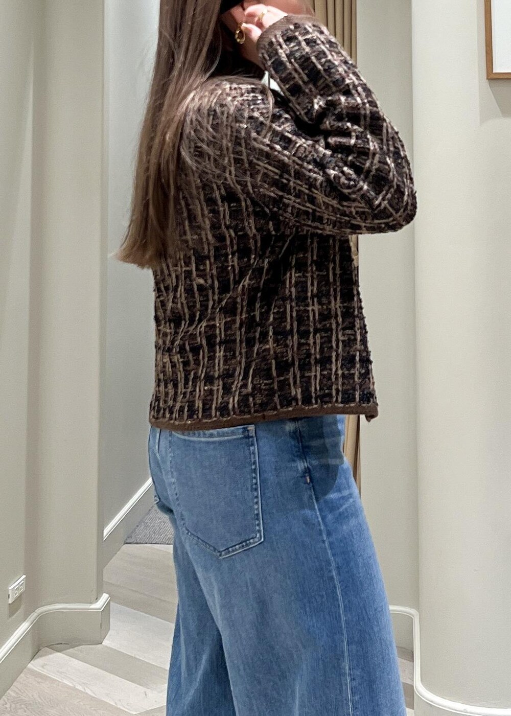 ブルー系のデニムパンツ、ブラック系のブーツ、ブラウン系のニット/セーターを着用したレディースの秋コーディネートの9枚目の写真