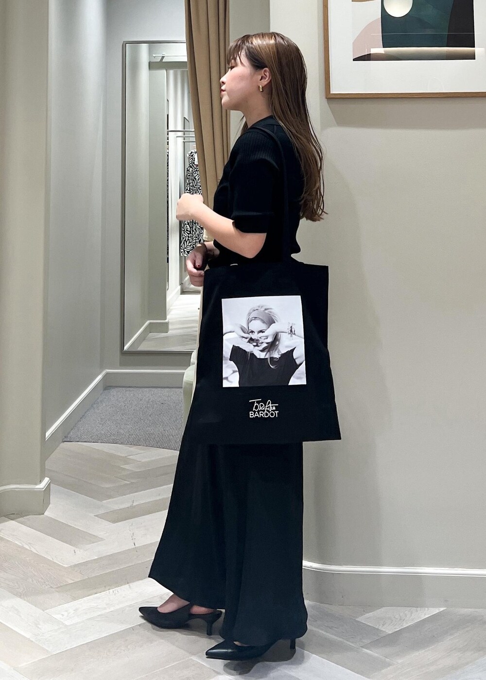 ブラック系のパンプス、ブラック系のスカート、ブラック系のニット/セーターを着用したレディースの秋コーディネートの3枚目の写真