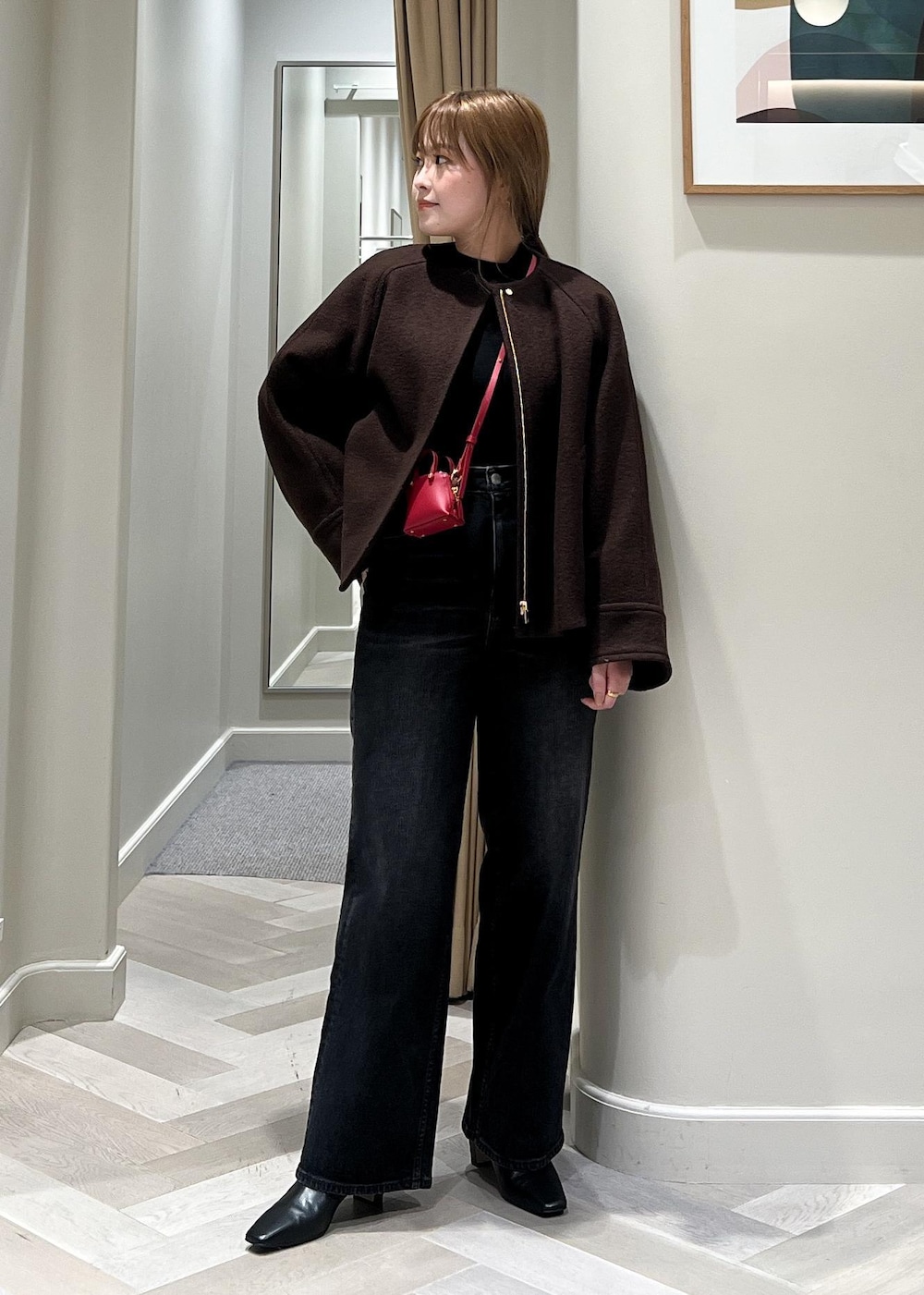 ブラック系のデニムパンツ、ブラック系のブーツ、ブラウン系のブルゾンを着用したレディースの秋コーディネートの5枚目の写真