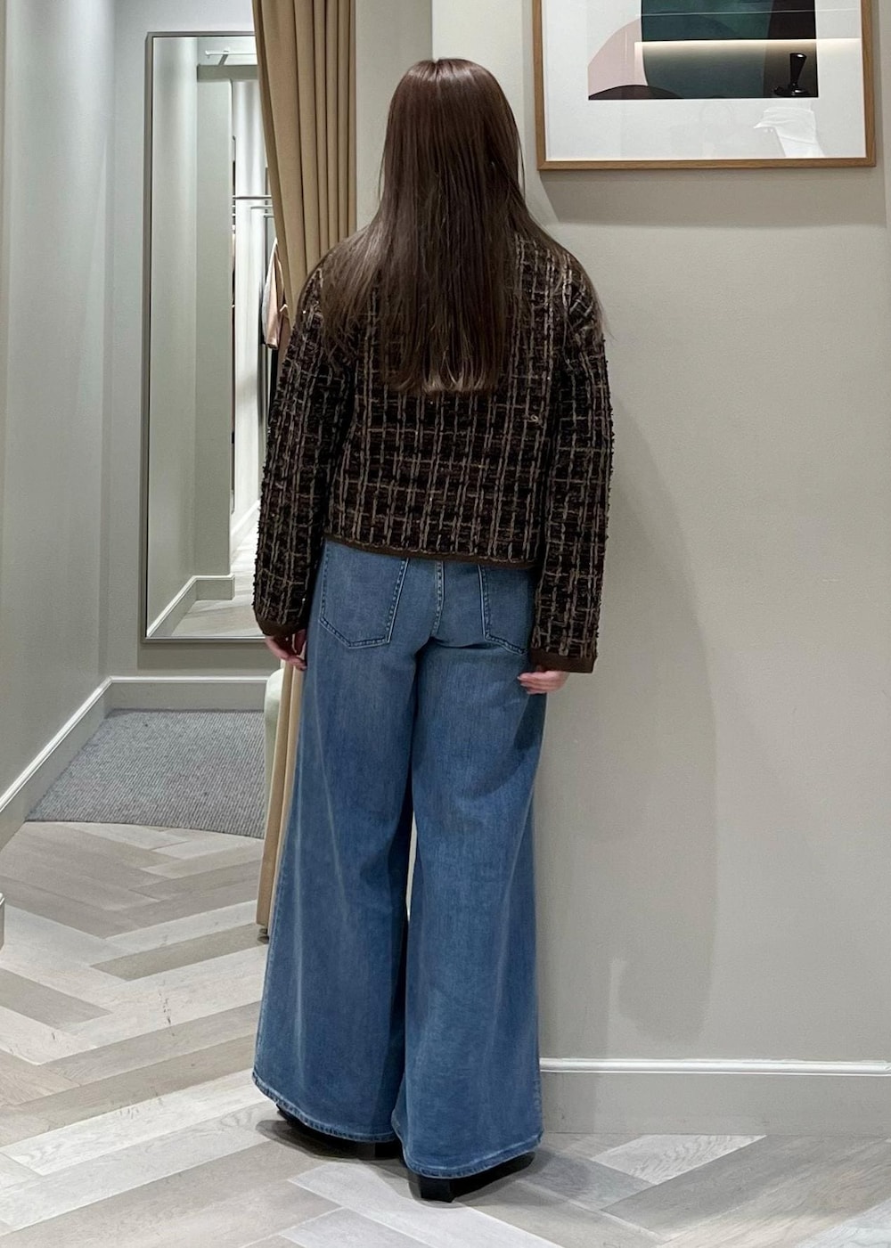 ブルー系のデニムパンツ、ブラック系のブーツ、ブラウン系のニット/セーターを着用したレディースの秋コーディネートの5枚目の写真