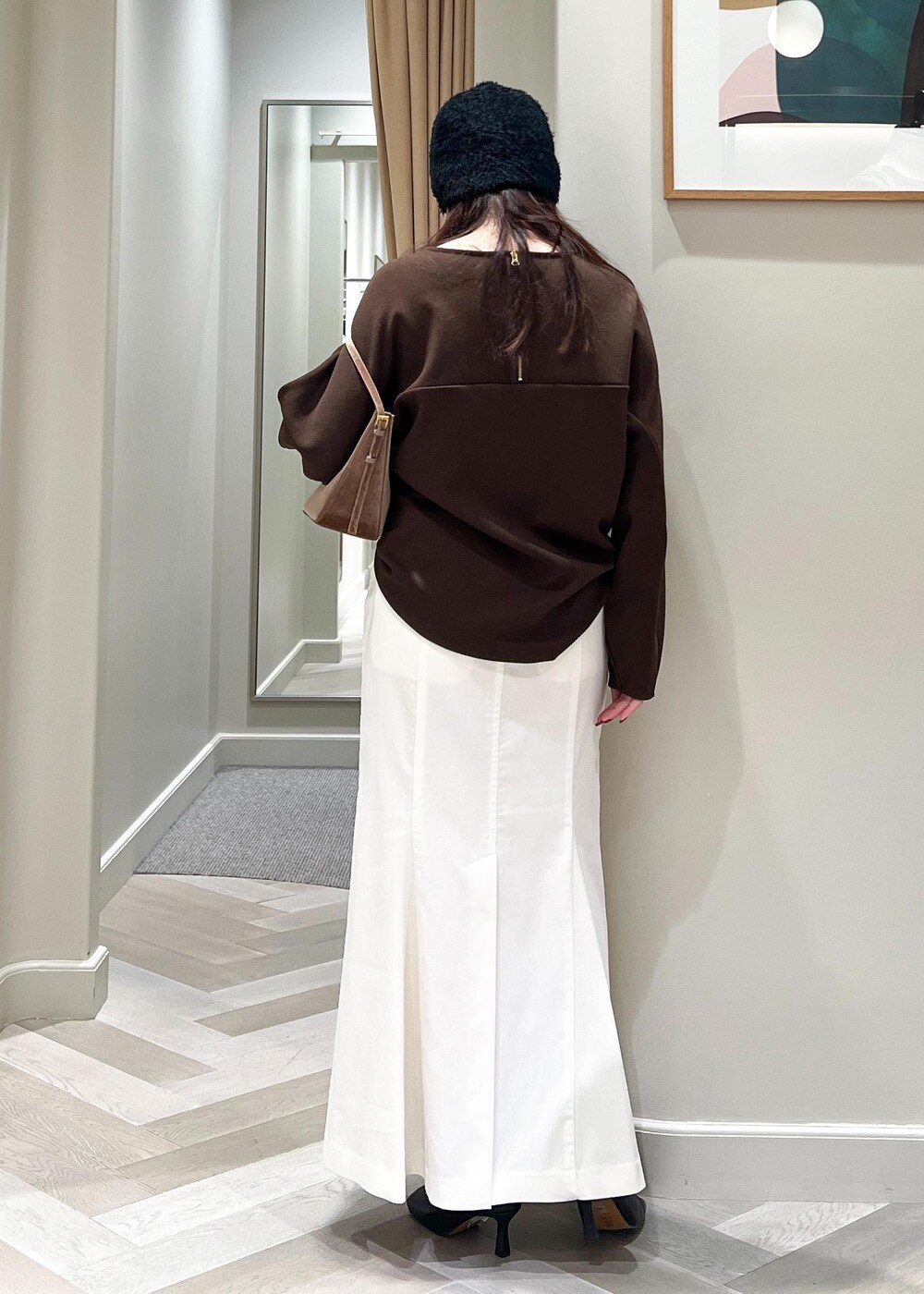 ブラック系のブーツ、ホワイト系のスカート、ブラウン系のTシャツ/カットソーを着用したレディースの秋コーディネートの4枚目の写真