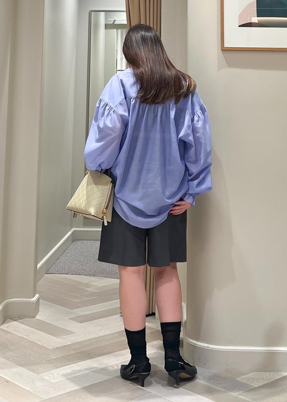 ブラック系のパンプス、グレー系のその他パンツ、ベージュ系のハンドバッグを着用したレディースの秋コーディネートの4枚目の写真