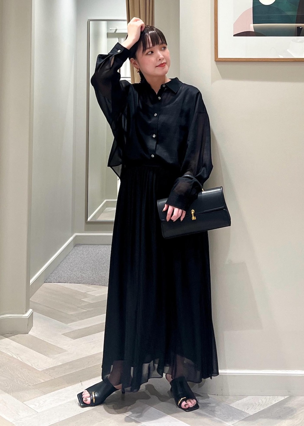 ブラック系のサンダル、ブラック系のショルダーバッグ、ブラック系のシャツ/ブラウスを着用したレディースの春コーディネートの2枚目の写真