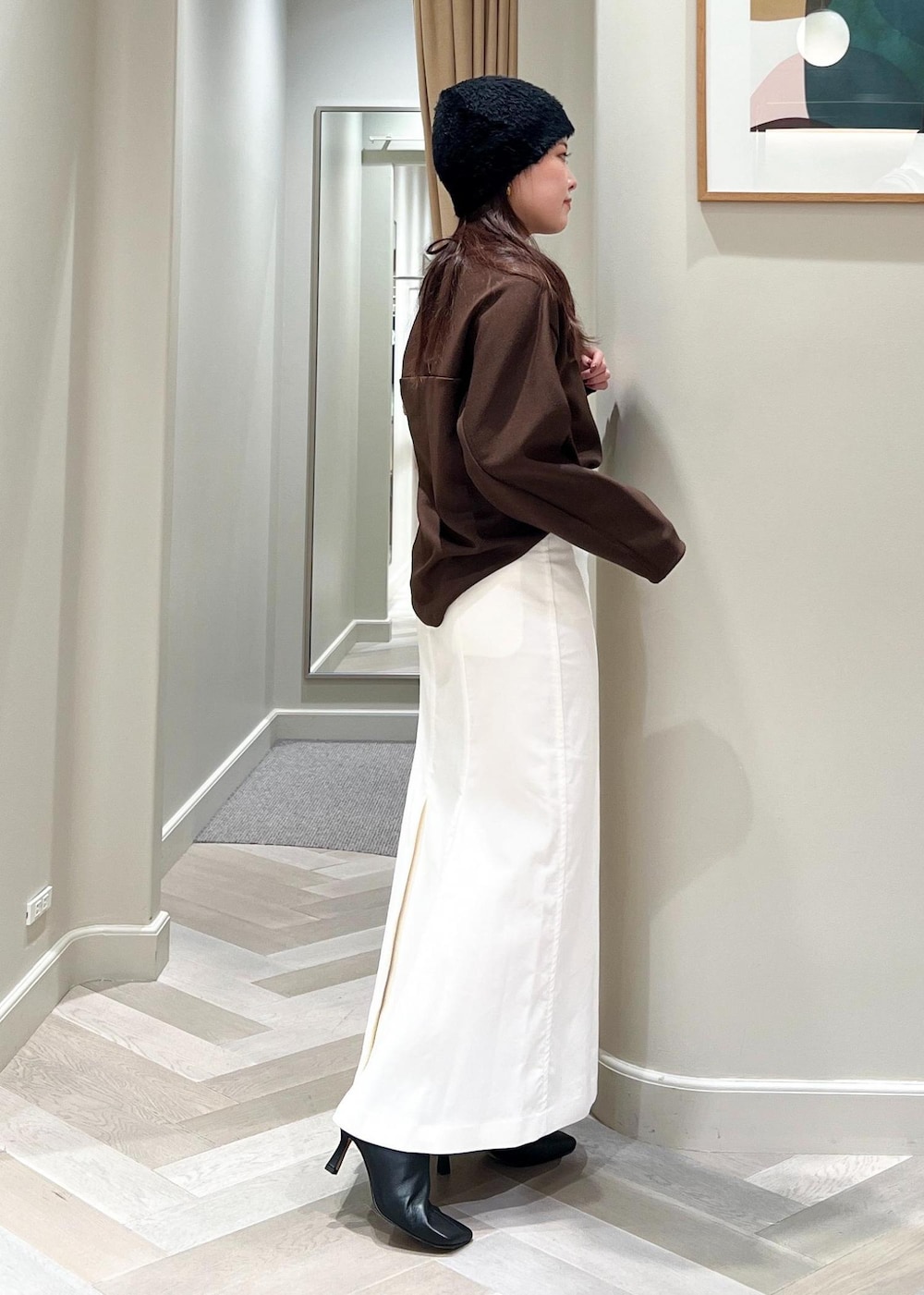 ブラック系のブーツ、ホワイト系のスカート、ブラウン系のTシャツ/カットソーを着用したレディースの秋コーディネートの3枚目の写真