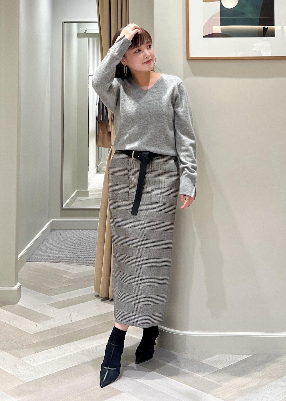 ブラック系のパンプス、ブラック系のスカート、グレー系のニット/セーターを着用したレディースの秋コーディネートの7枚目の写真