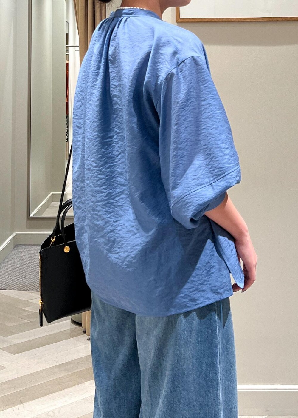 ブラック系のハンドバッグ、ブルー系のデニムパンツ、ブルー系のシャツ/ブラウスを着用したレディースの夏コーディネートの8枚目の写真