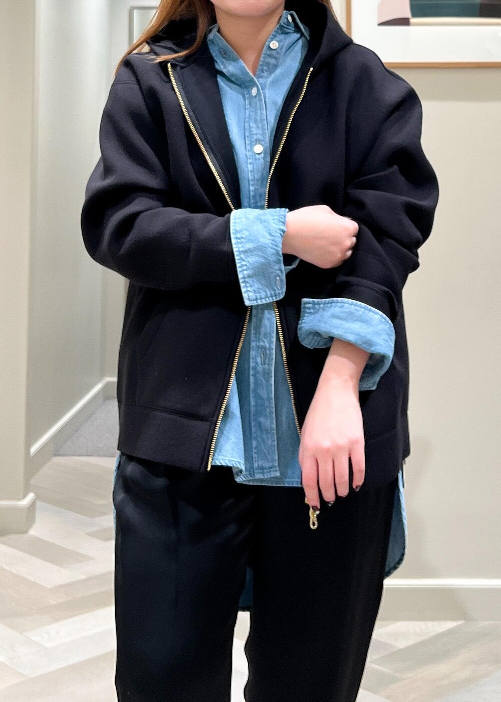 ブラック系のパンプス、ブルー系のシャツ/ブラウス、ブラック系のパーカーを着用したレディースの冬コーディネートの7枚目の写真