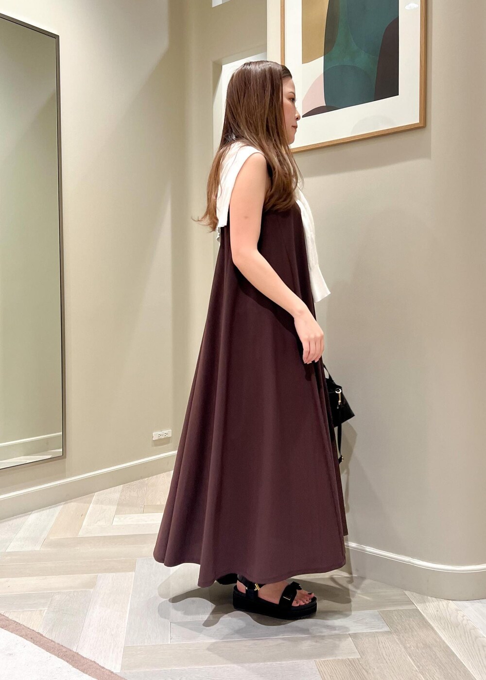 ブラック系のトートバッグ、ブラウン系のワンピース、ブラック系のサンダルを着用したレディースの夏コーディネートの3枚目の写真