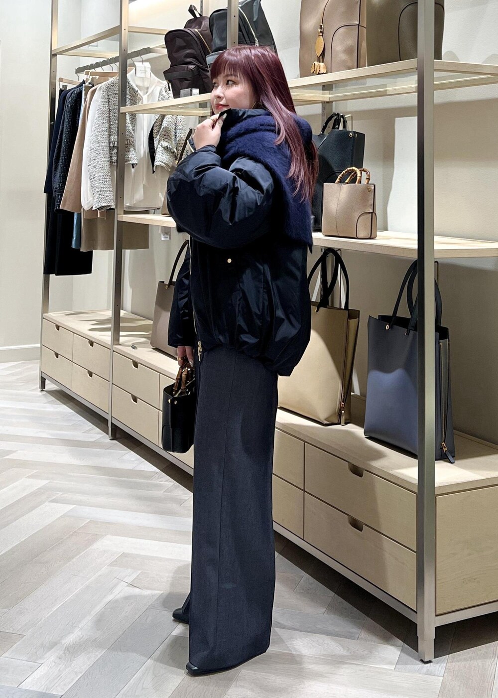 ブラック系のブーツ、グレー系のニット/セーター、ブルー系のその他パンツを着用したレディースの秋コーディネートの3枚目の写真