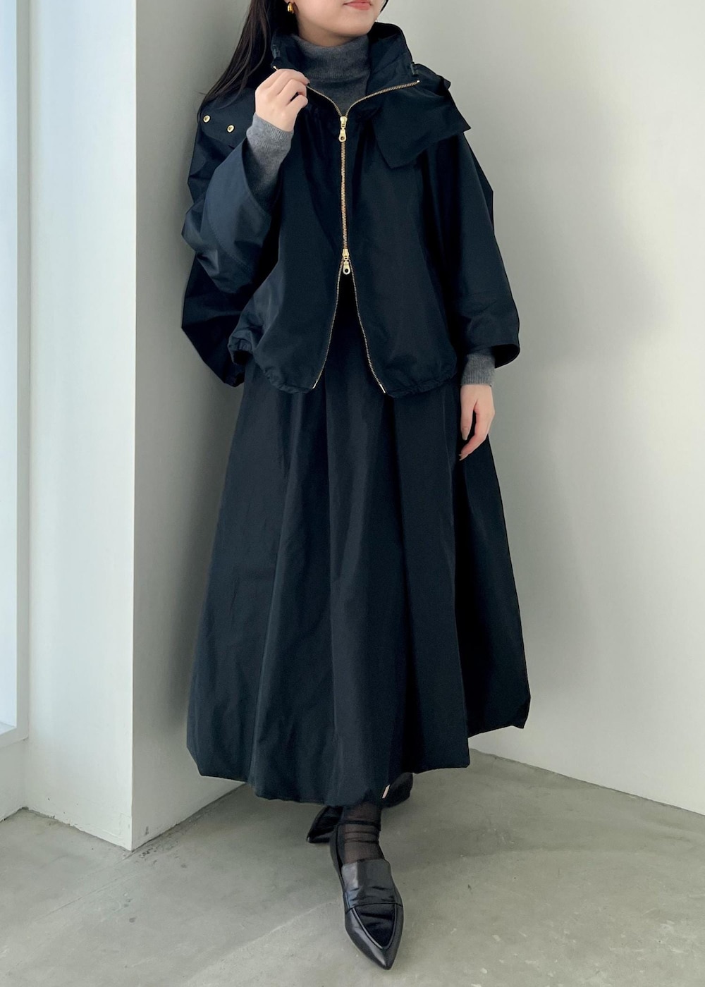 グレー系のニット/セーター、ブルー系のマウンテンパーカー、ブラック系のパンプスを着用したレディースの冬コーディネートの3枚目の写真