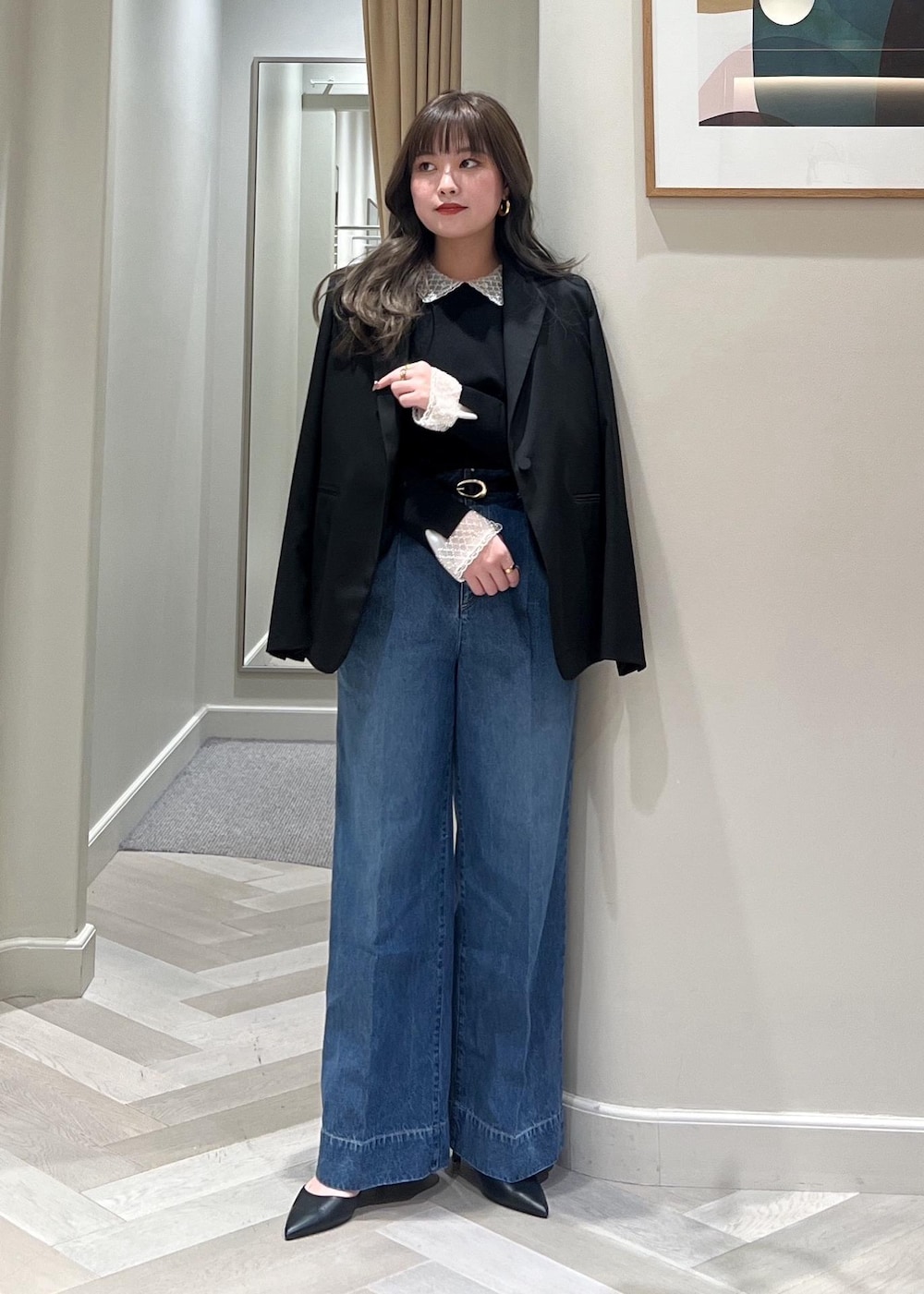 ブルー系のデニムパンツ、ブラック系のテーラードジャケット、ブラック系のベルトを着用したレディースの冬コーディネートの6枚目の写真