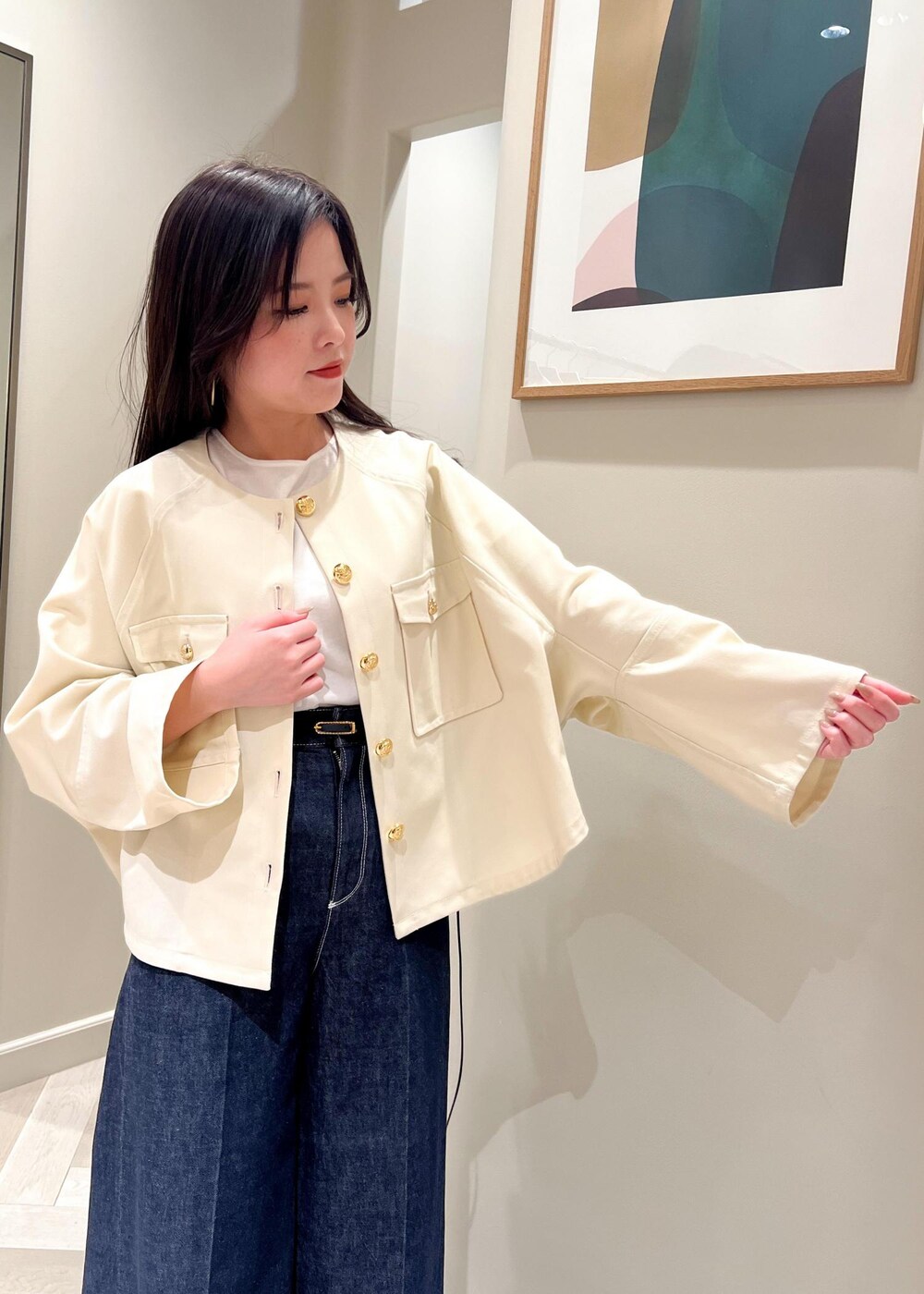 ブラック系のパンプス、ホワイト系のニット/セーター、ブルー系のデニムパンツを着用したレディースの春コーディネートの7枚目の写真