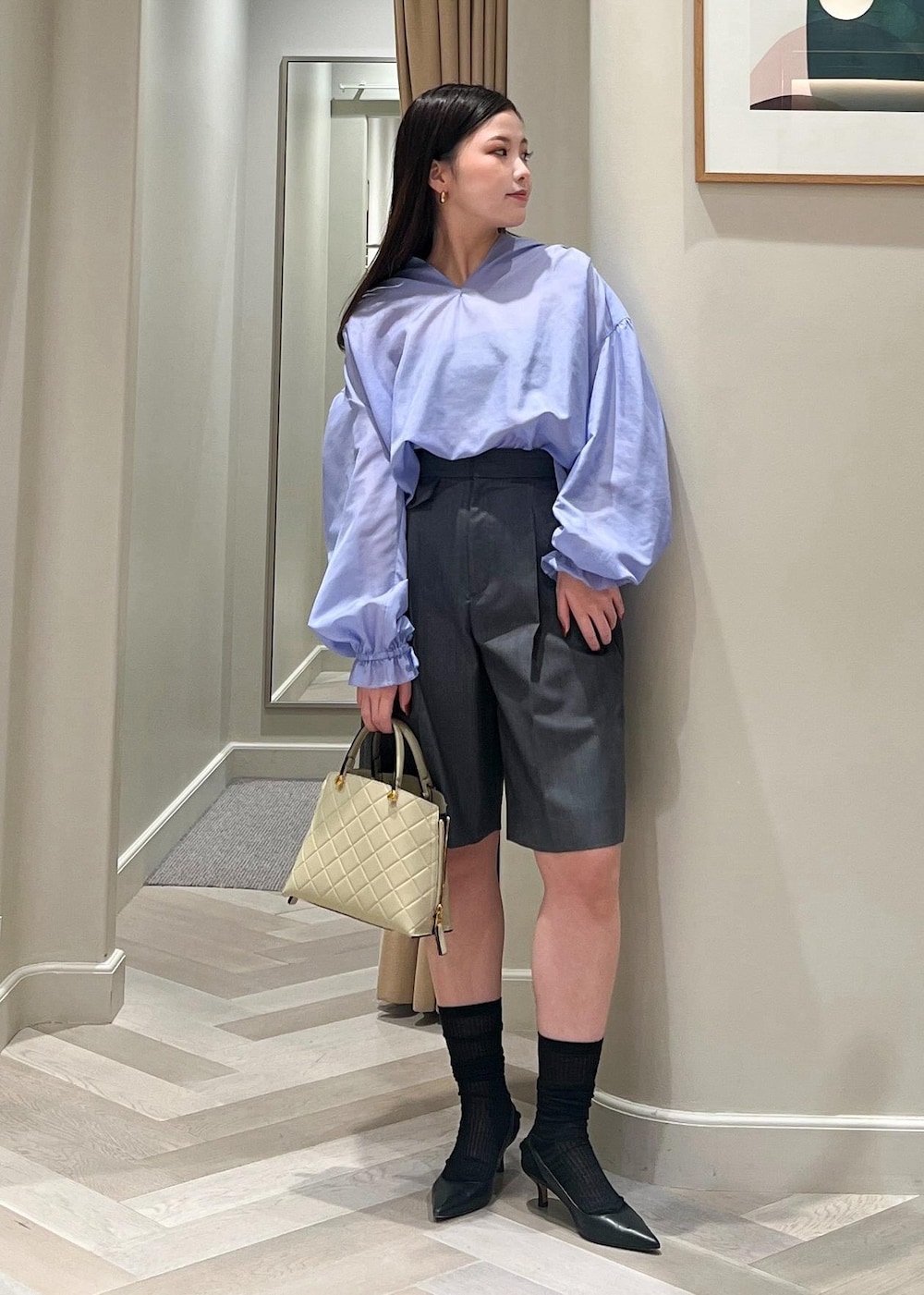 ブラック系のパンプス、グレー系のその他パンツ、ベージュ系のハンドバッグを着用したレディースの秋コーディネートの2枚目の写真