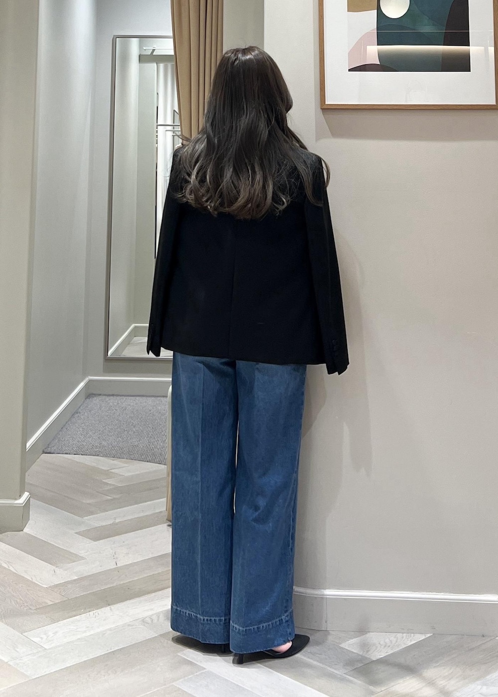 ブルー系のデニムパンツ、ブラック系のテーラードジャケット、ブラック系のベルトを着用したレディースの冬コーディネートの5枚目の写真