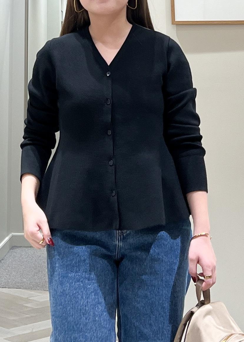 ブラック系のニット/セーター、ベージュ系のバックパック/リュック、ブルー系のデニムパンツを着用したレディースの冬コーディネートの7枚目の写真