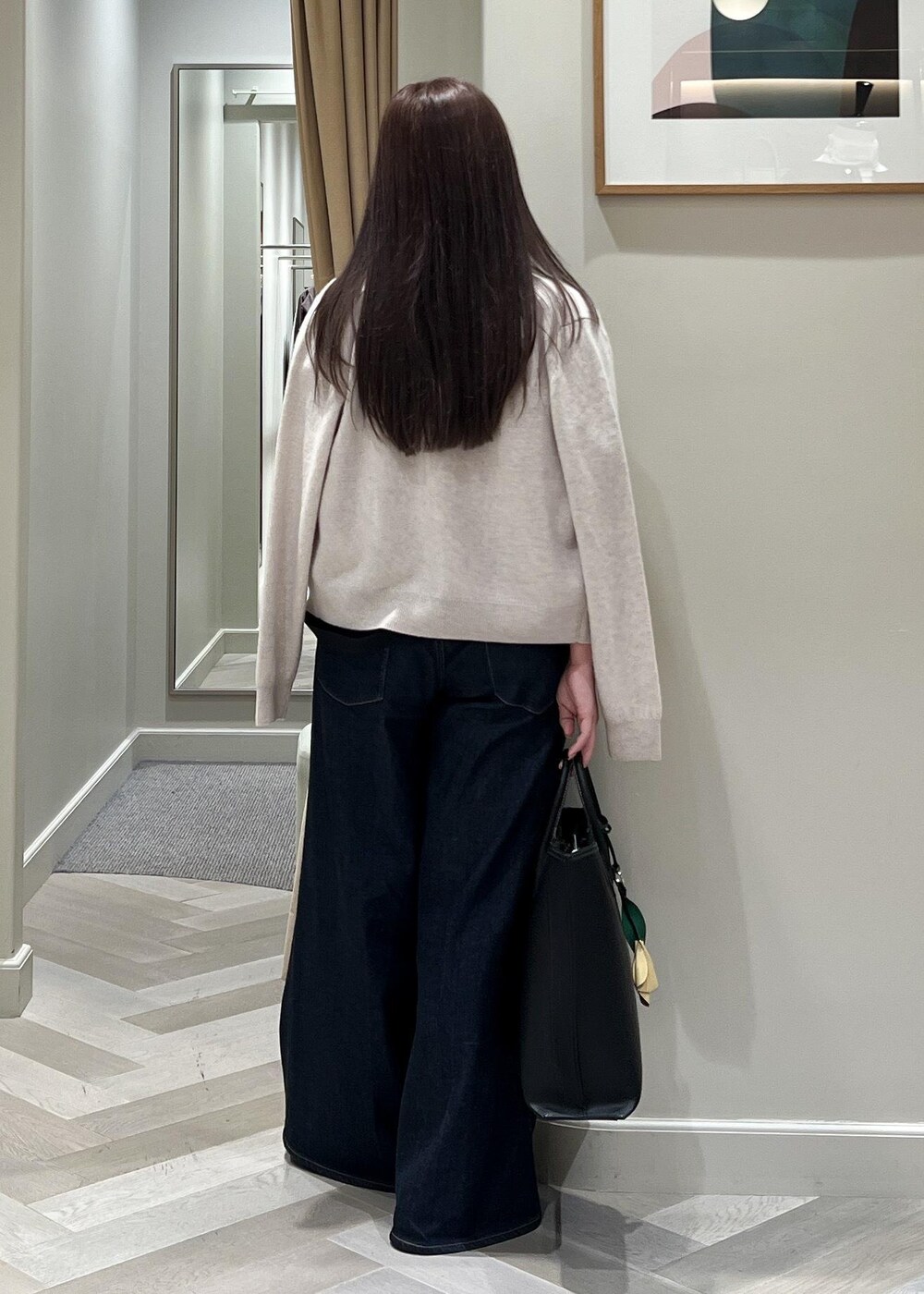 ベージュ系のカーディガン/ボレロ、ベージュ系のニット/セーター、ブルー系のデニムパンツを着用したレディースの秋コーディネートの4枚目の写真