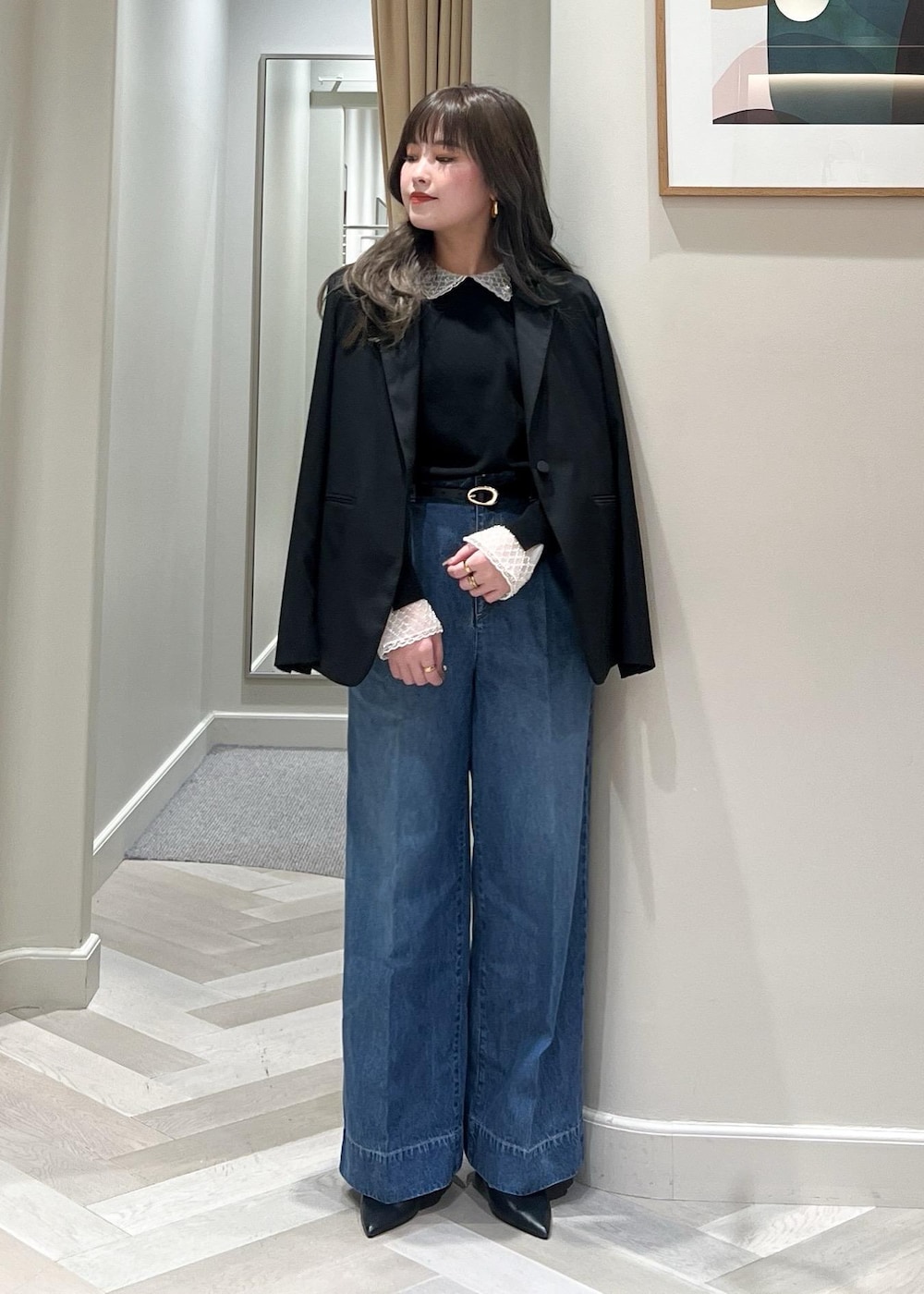 ブルー系のデニムパンツ、ブラック系のテーラードジャケット、ブラック系のベルトを着用したレディースの冬コーディネートの2枚目の写真