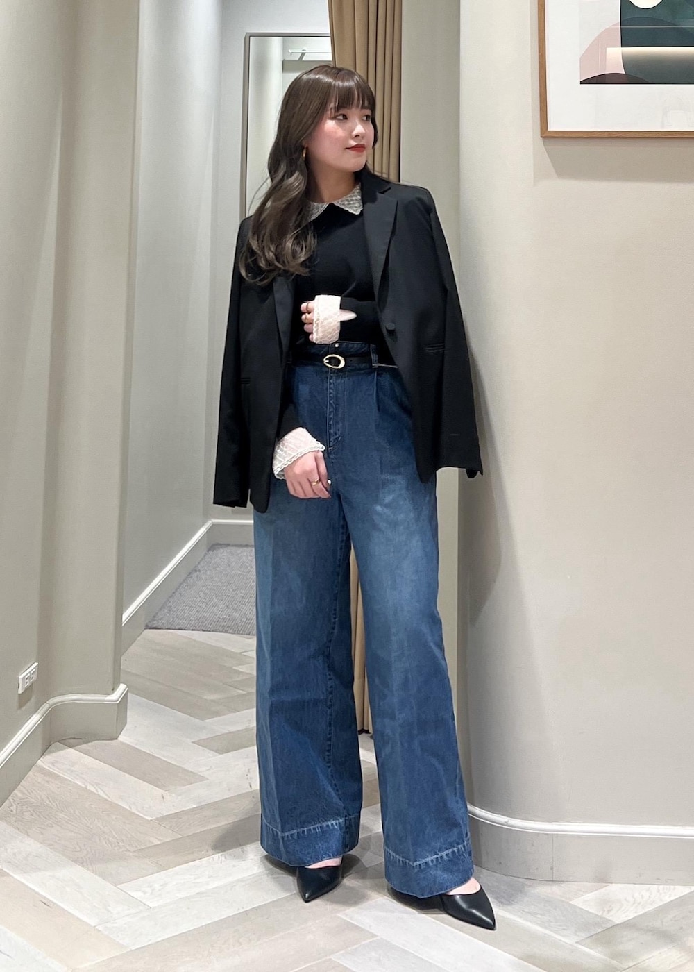 ブルー系のデニムパンツ、ブラック系のテーラードジャケット、ブラック系のベルトを着用したレディースの冬コーディネートの3枚目の写真