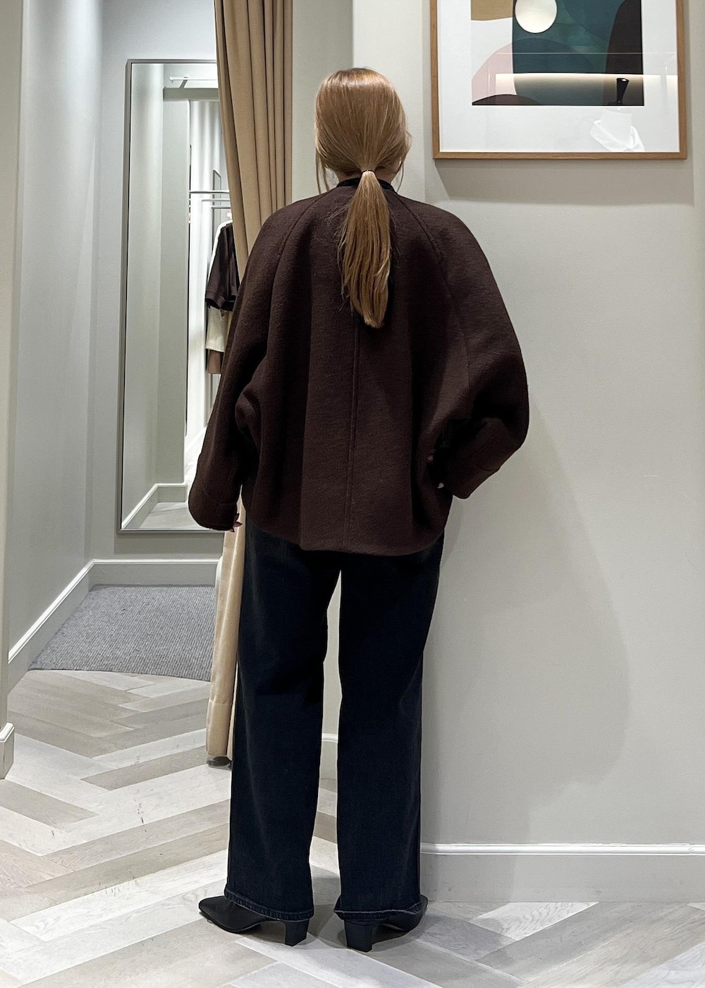 ブラック系のデニムパンツ、ブラック系のブーツ、ブラウン系のブルゾンを着用したレディースの秋コーディネートの4枚目の写真