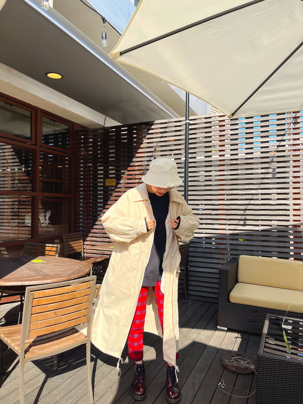 ベージュ系のジャケット/アウター、ブラウン系のブーツ、レッド系のパンツを着用したレディースの冬コーディネートの2枚目の写真