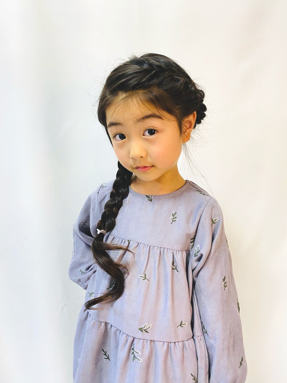 パープル系のワンピース、ブラウン系のブーツを着用したキッズの冬コーディネートの3枚目の写真