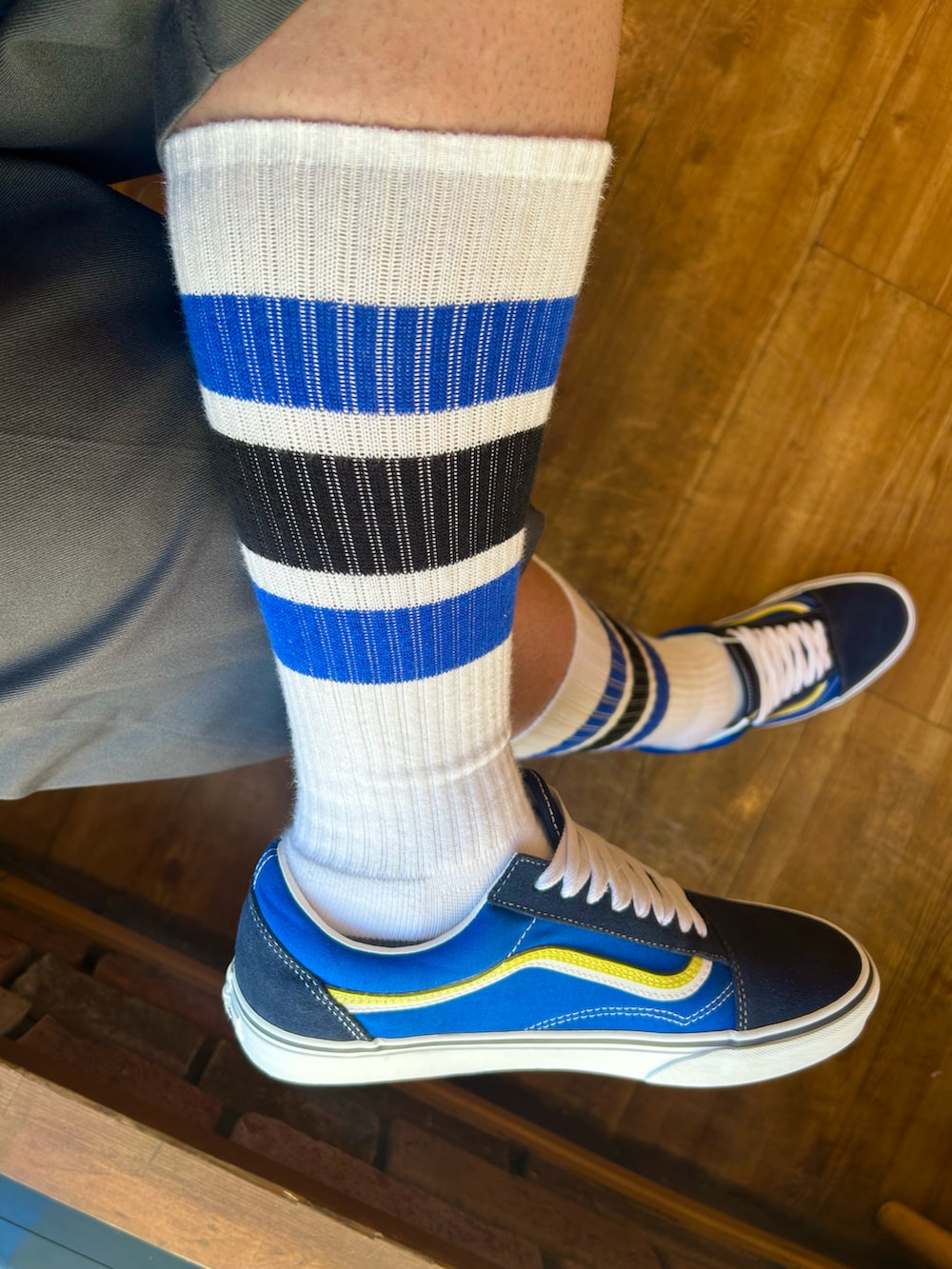 グレー系のチノパンツ、ブルー系のスニーカー、ホワイト系のソックス/靴下を着用したメンズの秋コーディネートの3枚目の写真