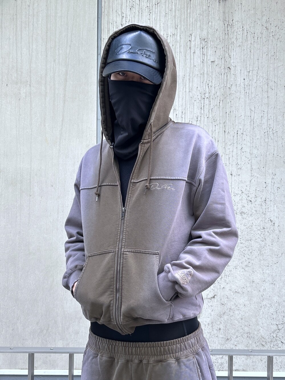 ブラウン系のパーカー、ブラウン系のスウェットパンツ、ブラック系のキャップを着用したメンズの冬コーディネートの5枚目の写真