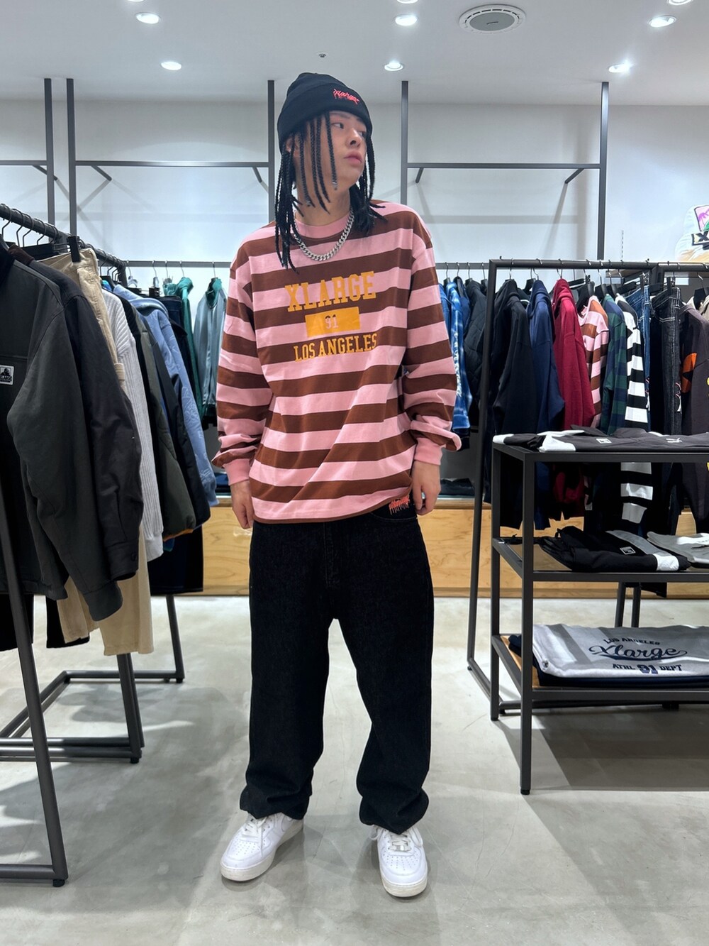 ピンク系のTシャツ/カットソー、ブラック系のデニムパンツ、ブラック系のニットキャップ/ビーニーを着用したメンズの秋コーディネートの4枚目の写真