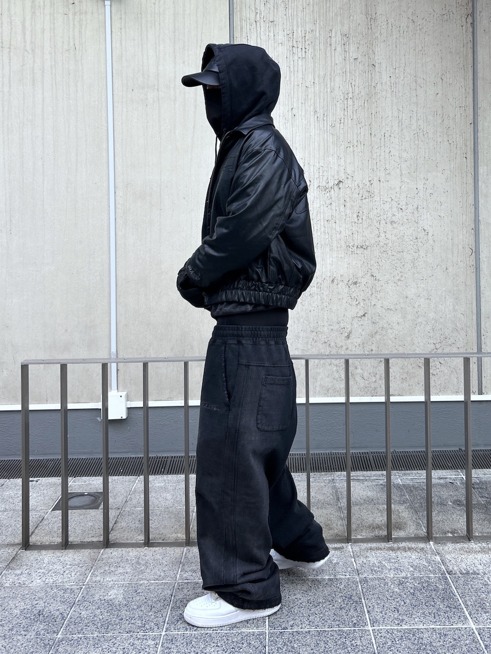 ブラック系のその他アウター、ブラック系のパーカー、ブラック系のスウェットパンツを着用したメンズの冬コーディネートの2枚目の写真