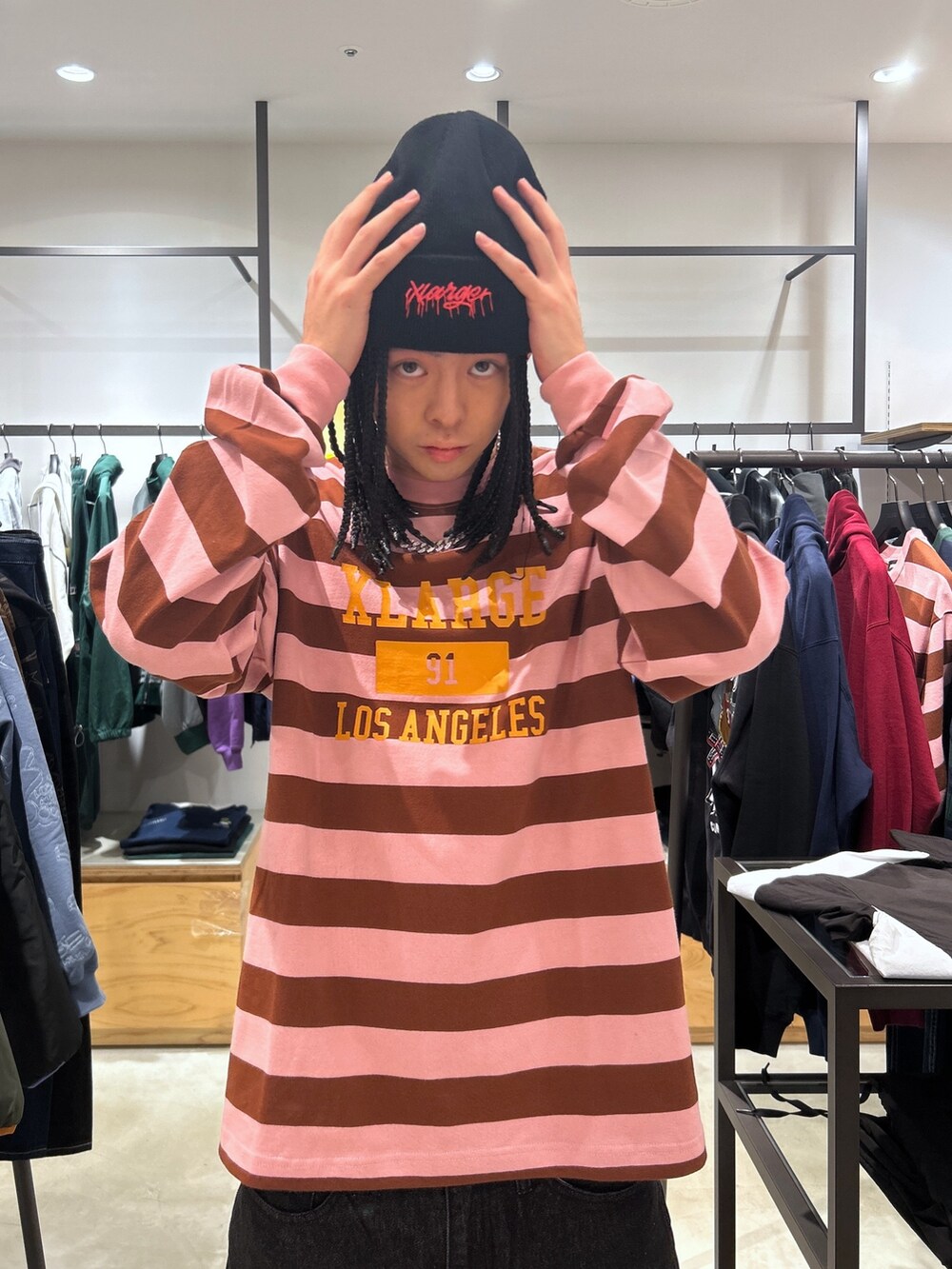 ピンク系のTシャツ/カットソー、ブラック系のデニムパンツ、ブラック系のニットキャップ/ビーニーを着用したメンズの秋コーディネートの2枚目の写真