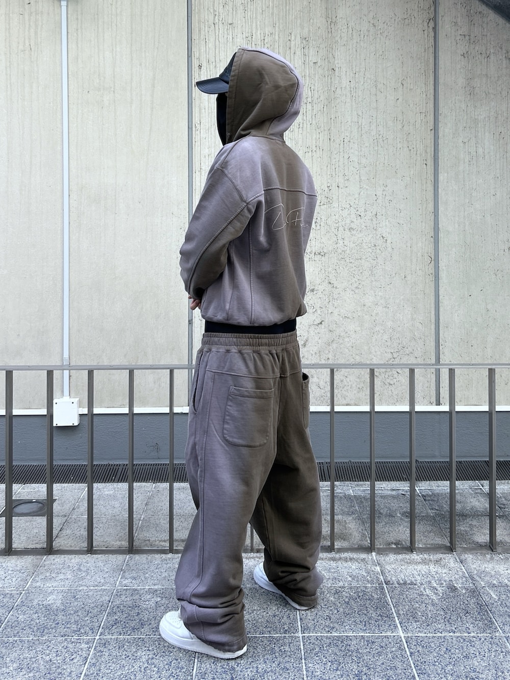 ブラウン系のパーカー、ブラウン系のスウェットパンツ、ブラック系のキャップを着用したメンズの冬コーディネートの3枚目の写真