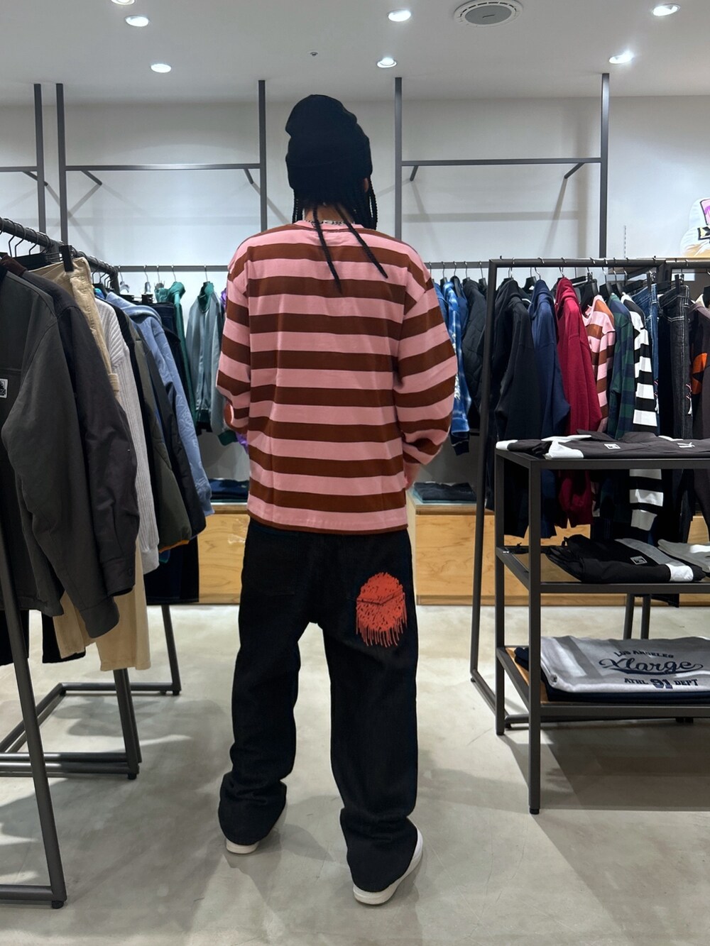 ピンク系のTシャツ/カットソー、ブラック系のデニムパンツ、ブラック系のニットキャップ/ビーニーを着用したメンズの秋コーディネートの3枚目の写真