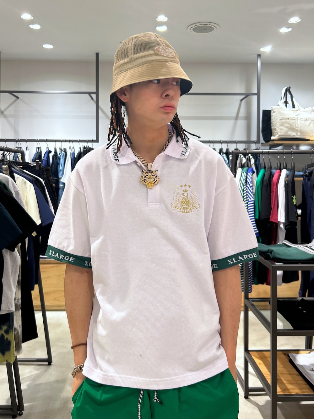 ホワイト系のポロシャツ、グリーン系のその他パンツ、ブラック系のハットを着用したメンズの夏コーディネートの3枚目の写真