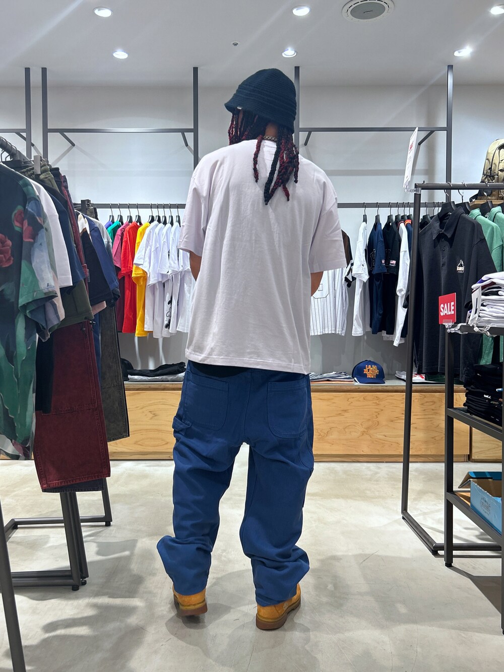 ホワイト系のTシャツ/カットソー、ブラック系のハットを着用したメンズの夏コーディネートの2枚目の写真