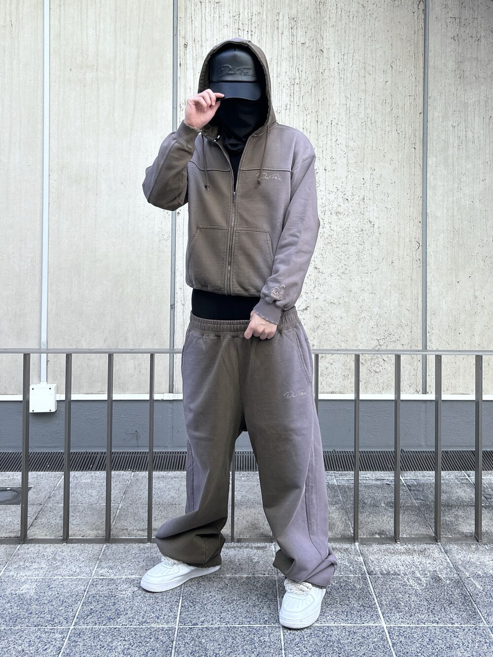 ブラウン系のパーカー、ブラウン系のスウェットパンツ、ブラック系のキャップを着用したメンズの冬コーディネートの2枚目の写真