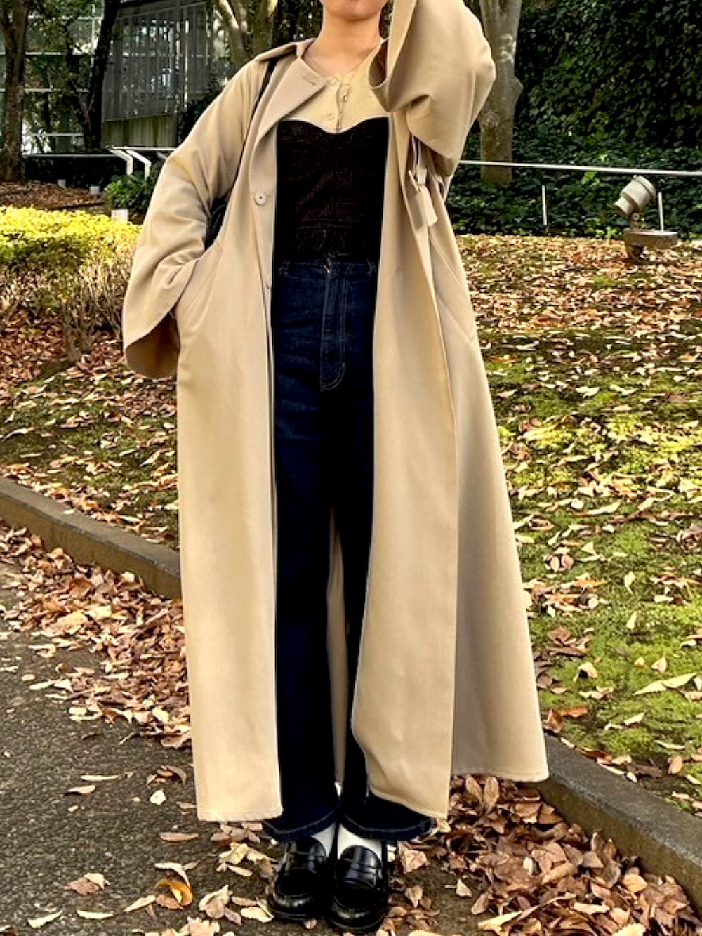 ブラック系のデニムパンツ、ブラック系のローファー、ブラック系のトップスを着用したレディースの冬コーディネートの2枚目の写真