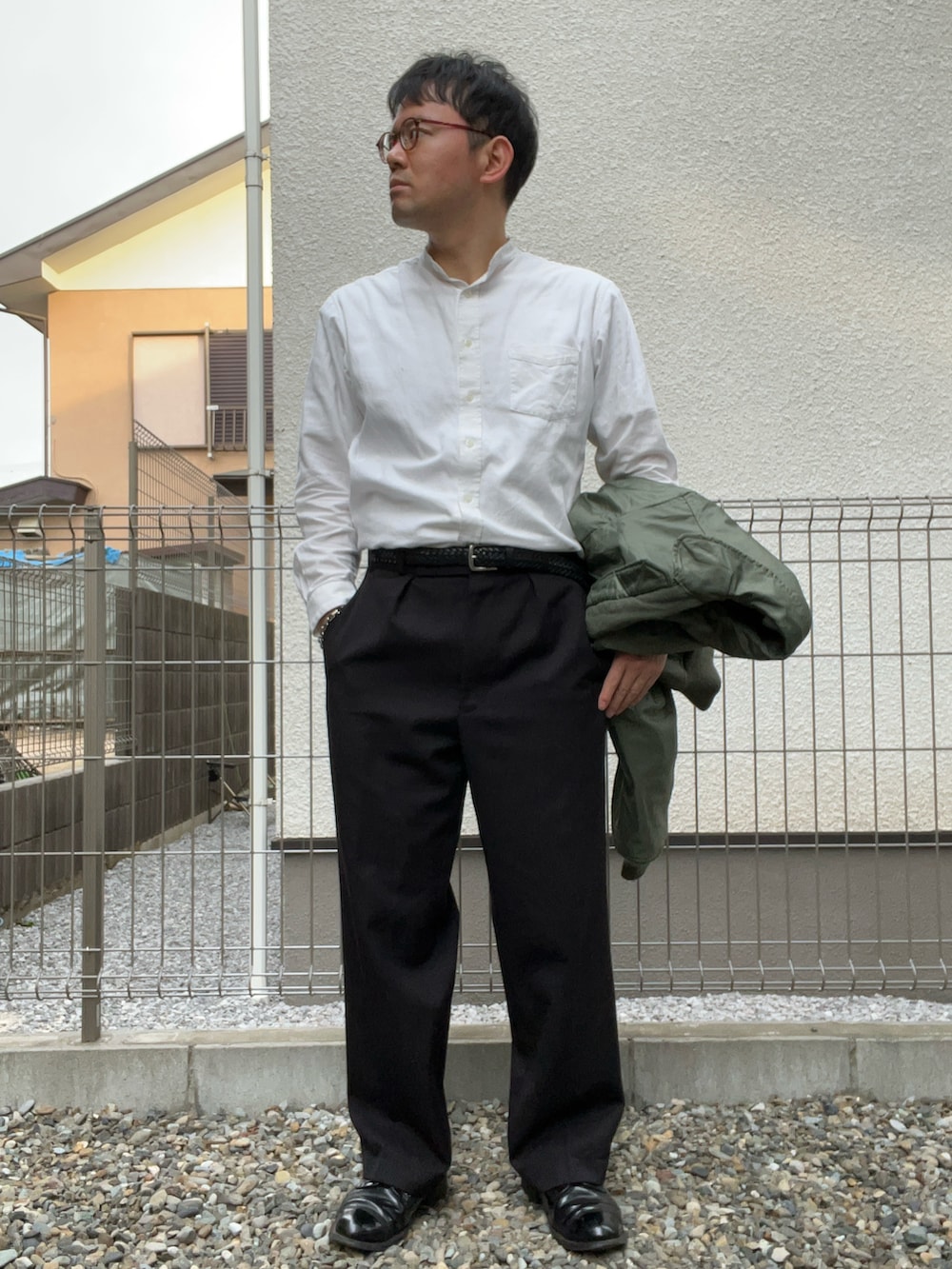 ホワイト系のシャツ/ブラウス、グリーン系のミリタリージャケット、ブラック系のスラックスを着用したメンズの冬コーディネートの3枚目の写真