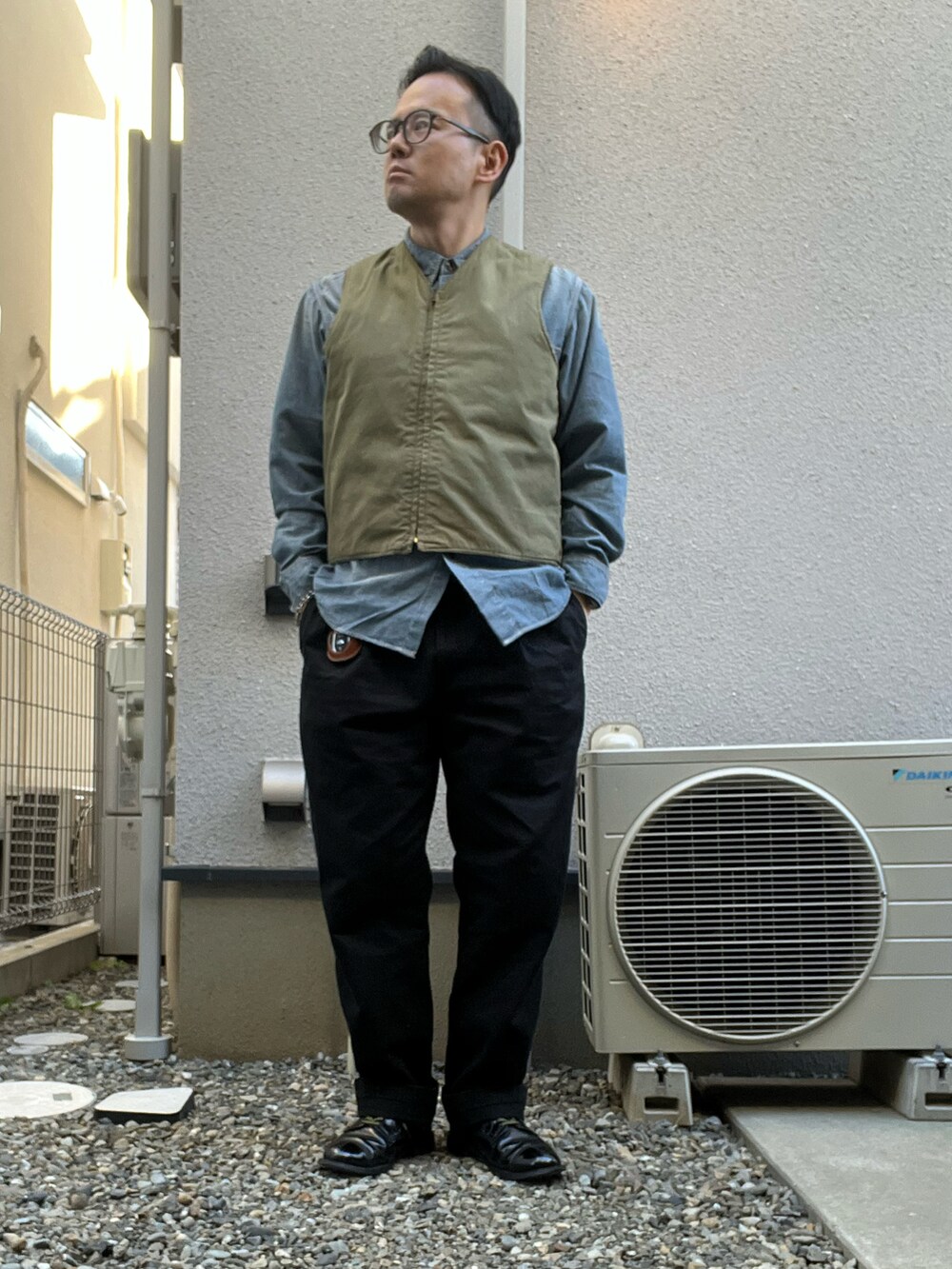 ブラック系のミリタリージャケット、ベージュ系のベスト、ブルー系のシャツ/ブラウスを着用したメンズの冬コーディネートの3枚目の写真