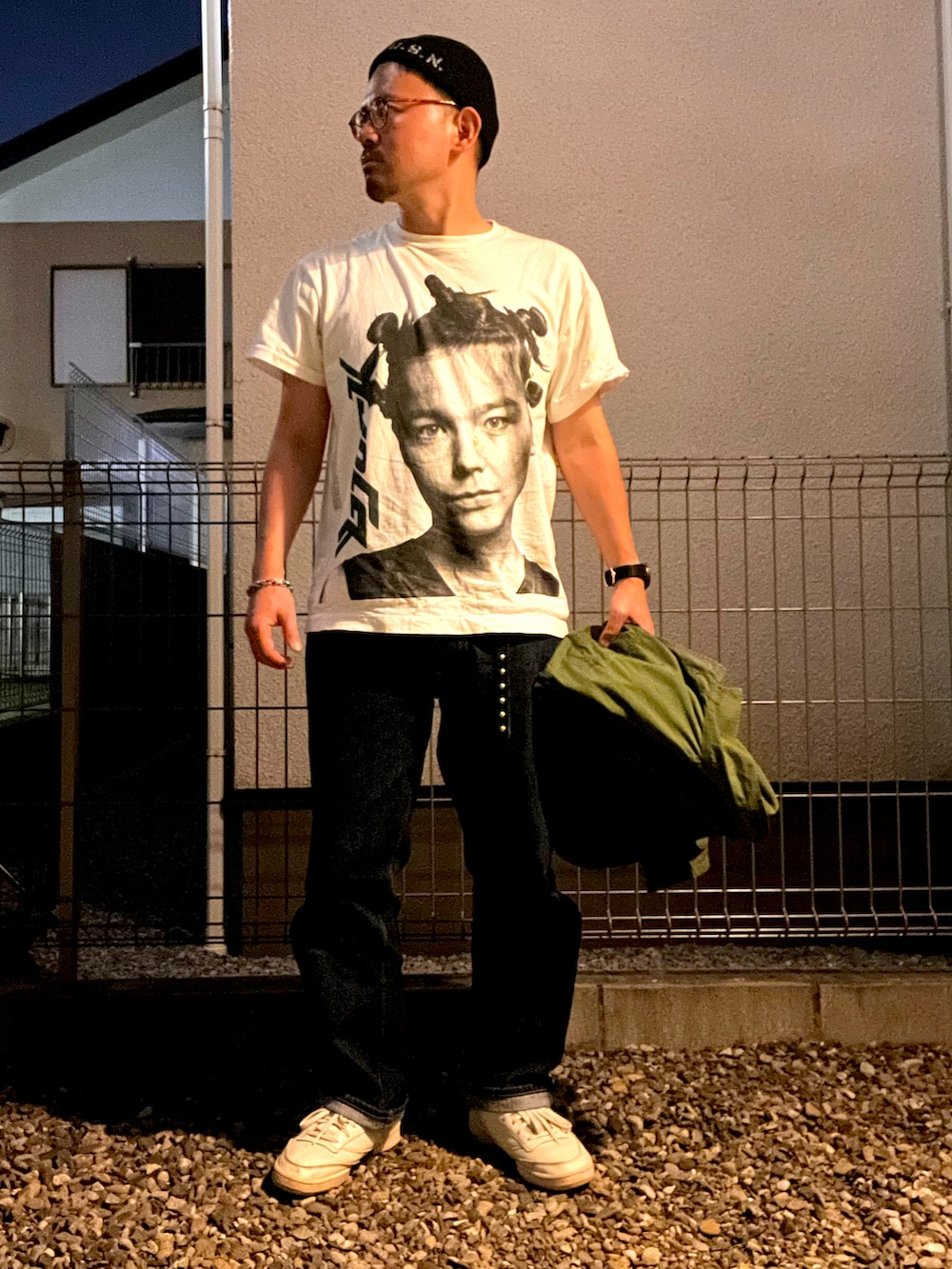ホワイト系のTシャツ/カットソー、グリーン系のミリタリージャケット、ブルー系のデニムパンツを着用したメンズの秋コーディネートの2枚目の写真